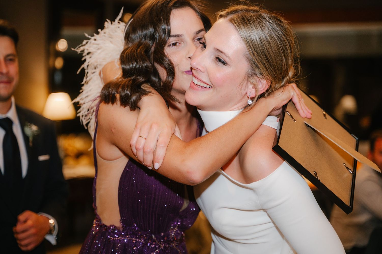 A joyful wedding celebration scene with a couple sharing an intimate moment in formal attire.
