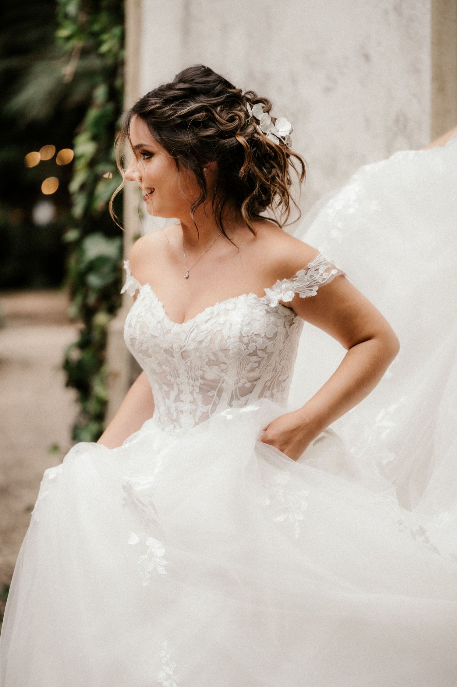 A stunning white wedding dress with delicate lace details and flowing tulle fabric captured in an elegant bridal portrait series.