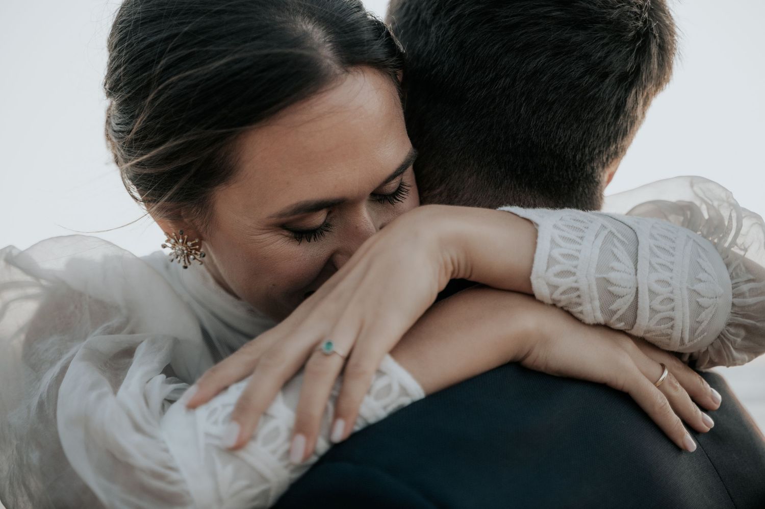 An intimate wedding moment captured in soft, romantic lighting with delicate lace details.