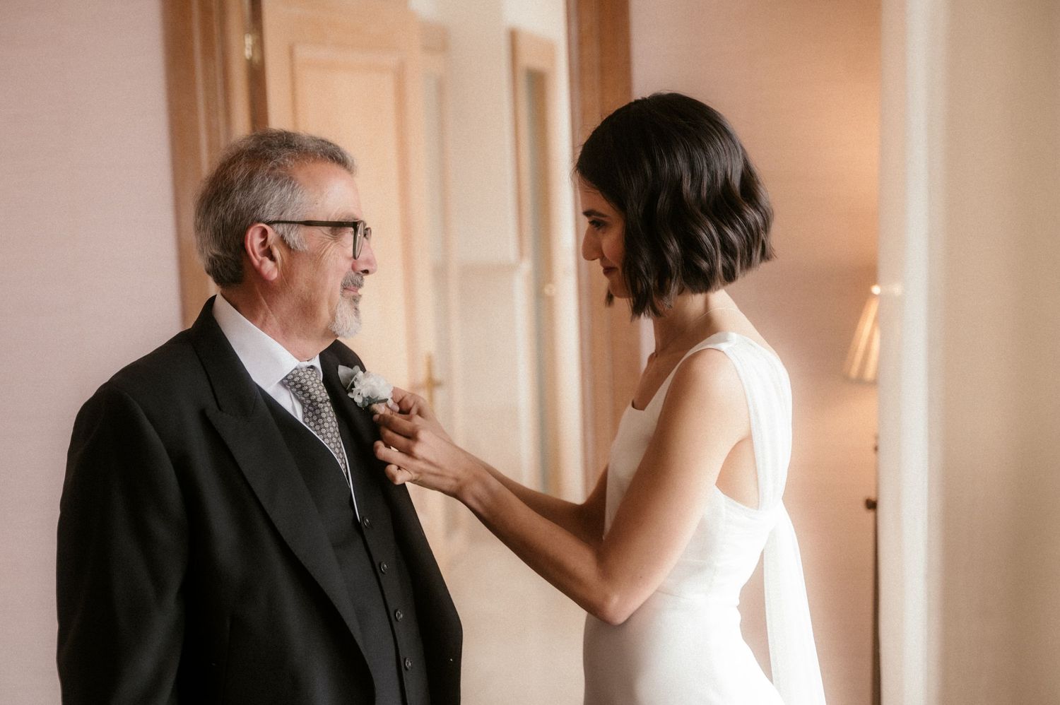 A sequence of four romantic moments between a couple in formal attire in a softly lit indoor setting.