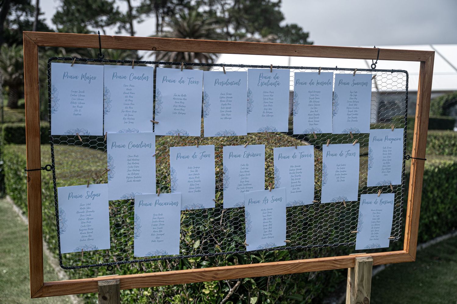 Outdoor bulletin board display with multiple papers posted across wooden frames against a green background.
