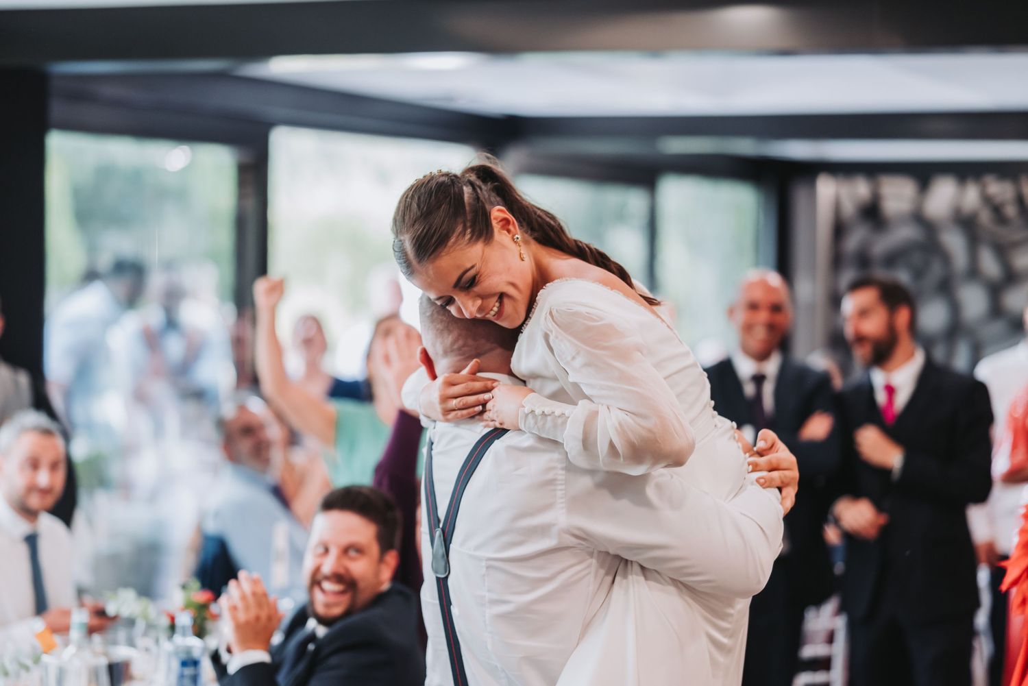 Wedding guests celebrating and dancing together in a festive indoor reception venue.