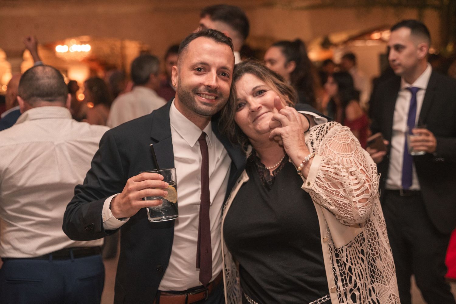 Couples dance together at an elegant evening wedding reception with warm ambient lighting.