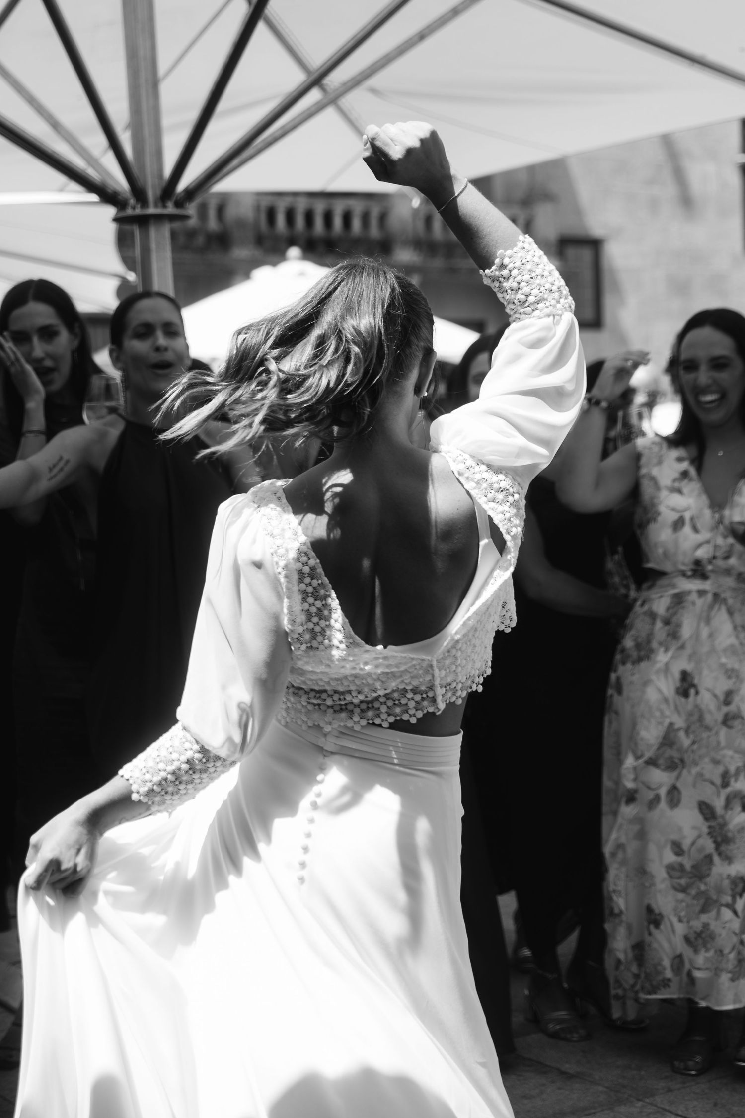 A series of black and white photos showing dancers in white dresses twirling and moving gracefully at a celebration.
