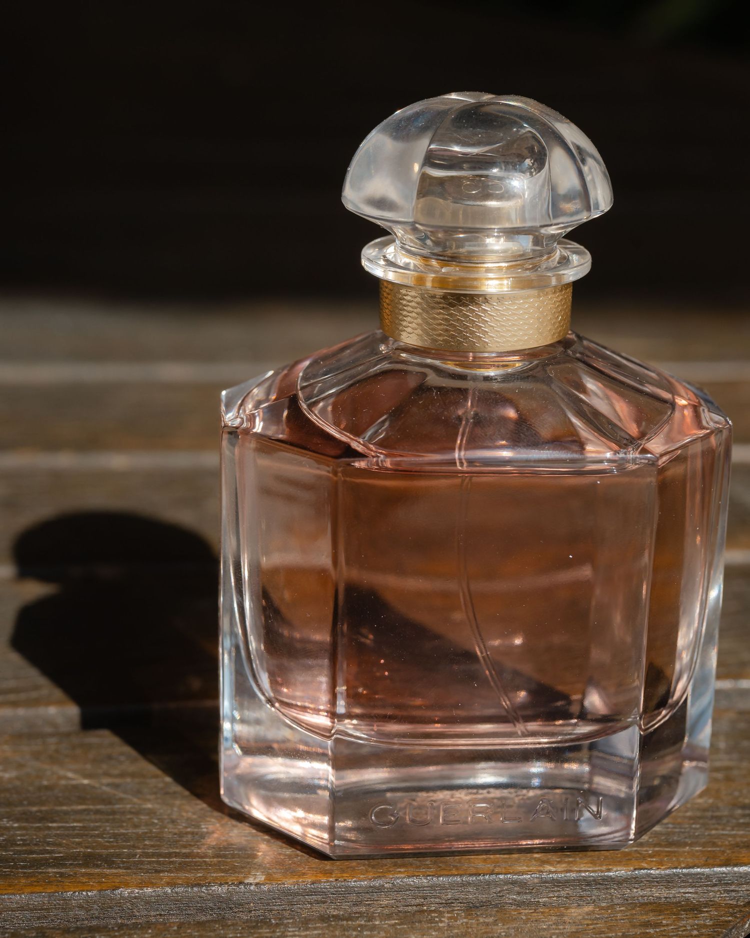 Elegant glass perfume bottle with pink liquid photographed from multiple angles.