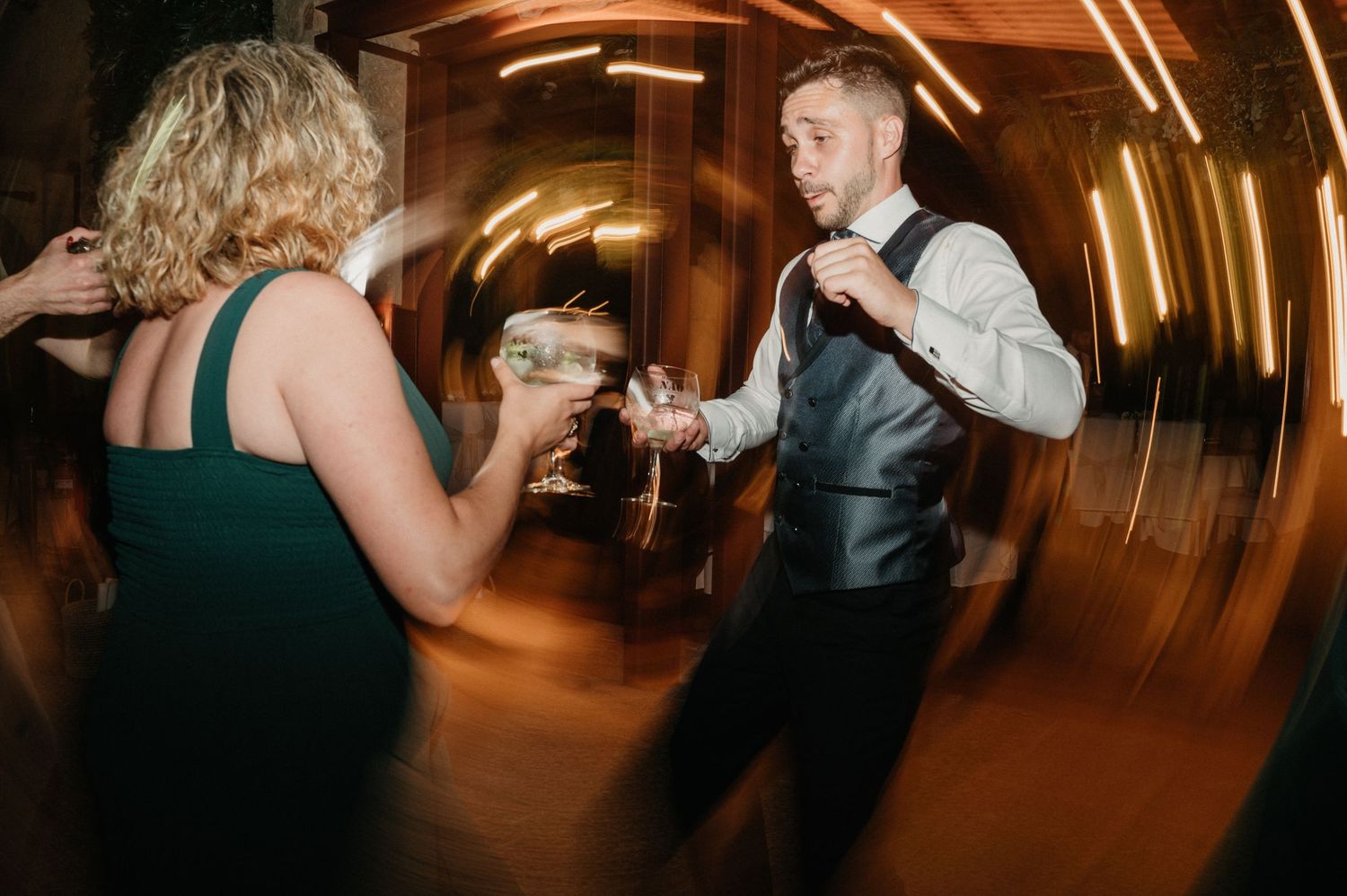 People dancing and celebrating at a party with motion blur and dramatic lighting effects.