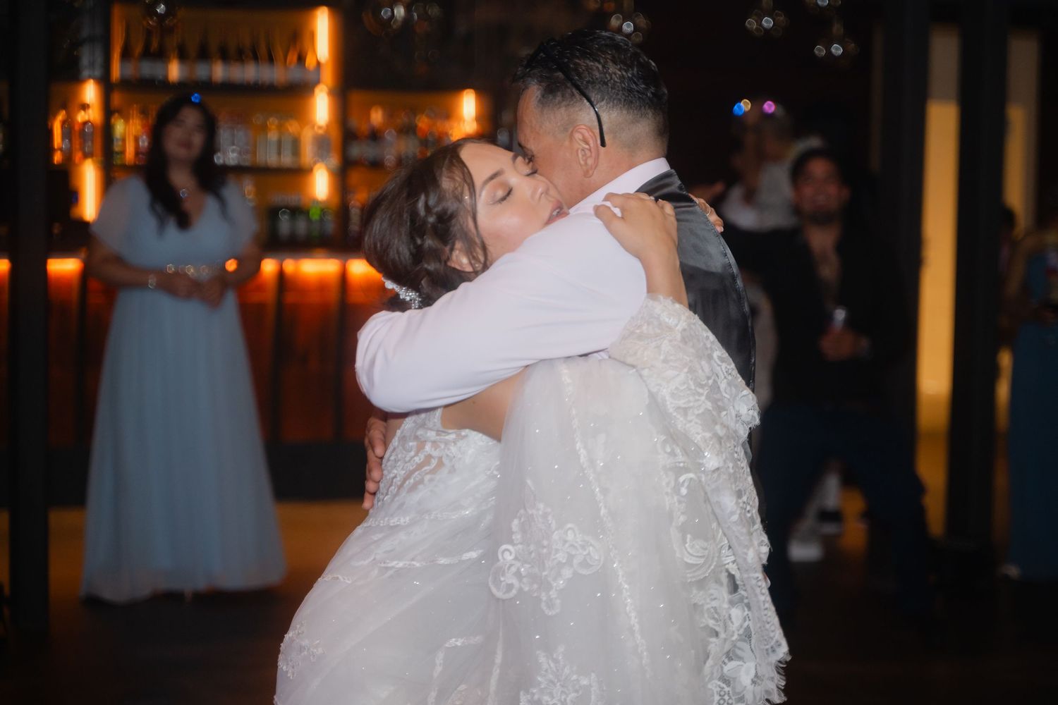 A romantic dance moment captured at an evening wedding reception with warm ambient lighting.