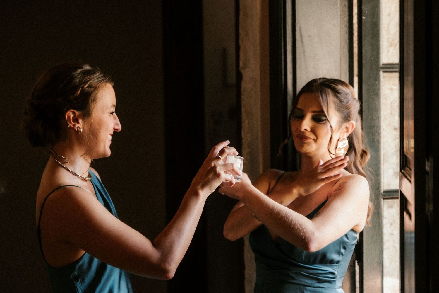 Two people dancing in an intimate moment by a window with dramatic natural lighting.