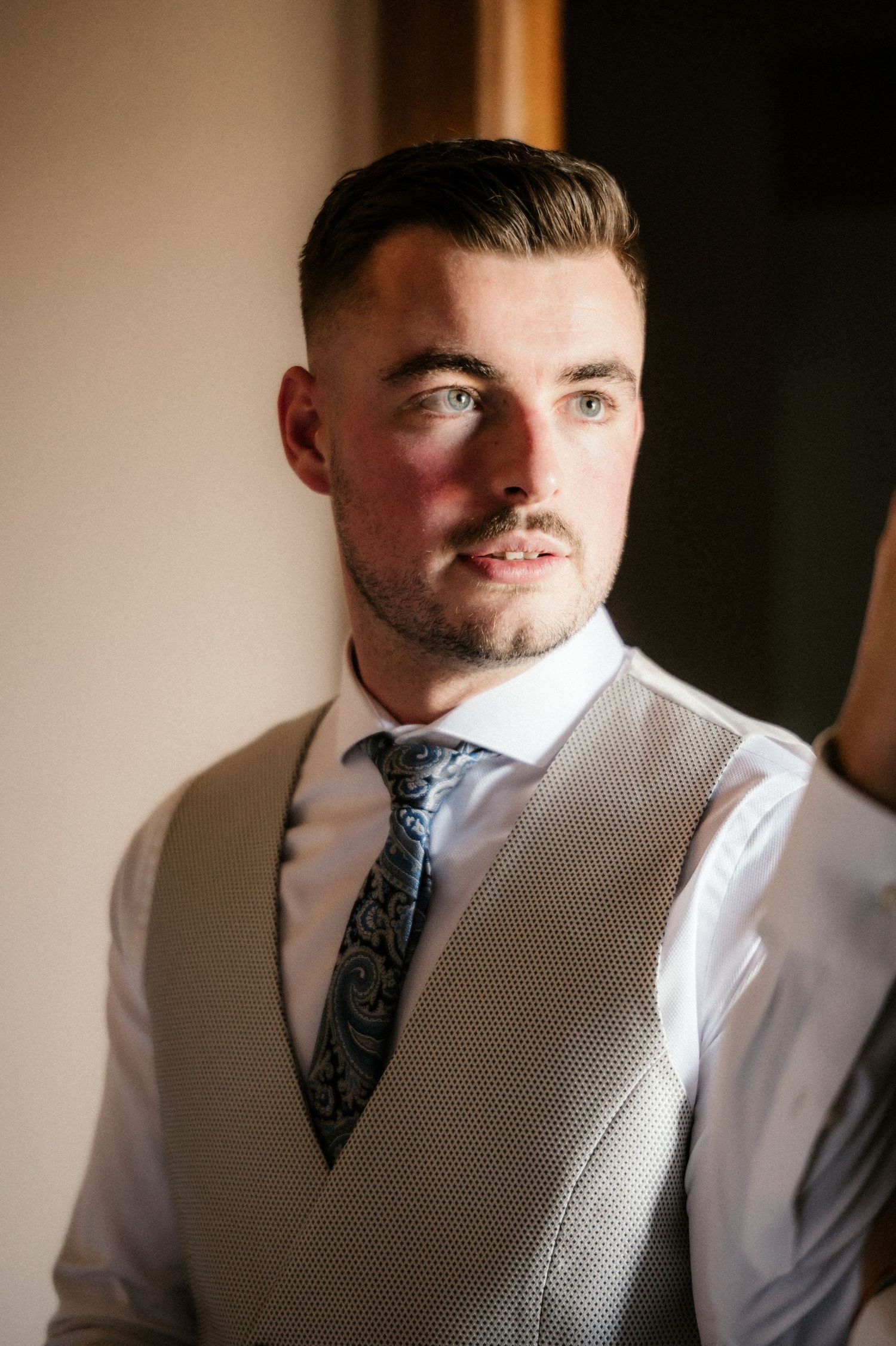 A series of profile shots showing a person in formal attire with a vest and tie.