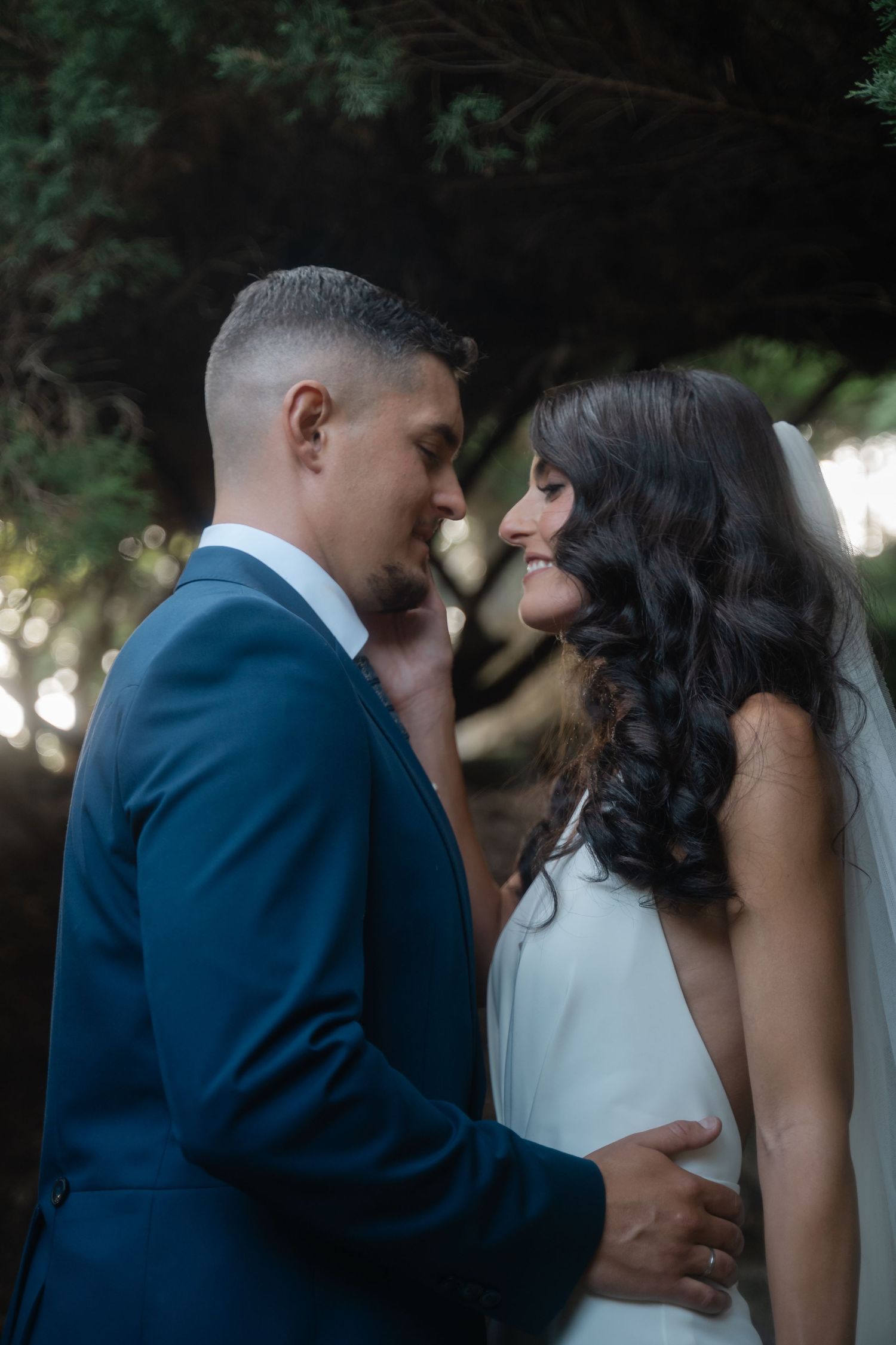 An intimate wedding sequence showing tender moments between newlyweds in a navy suit and white dress.