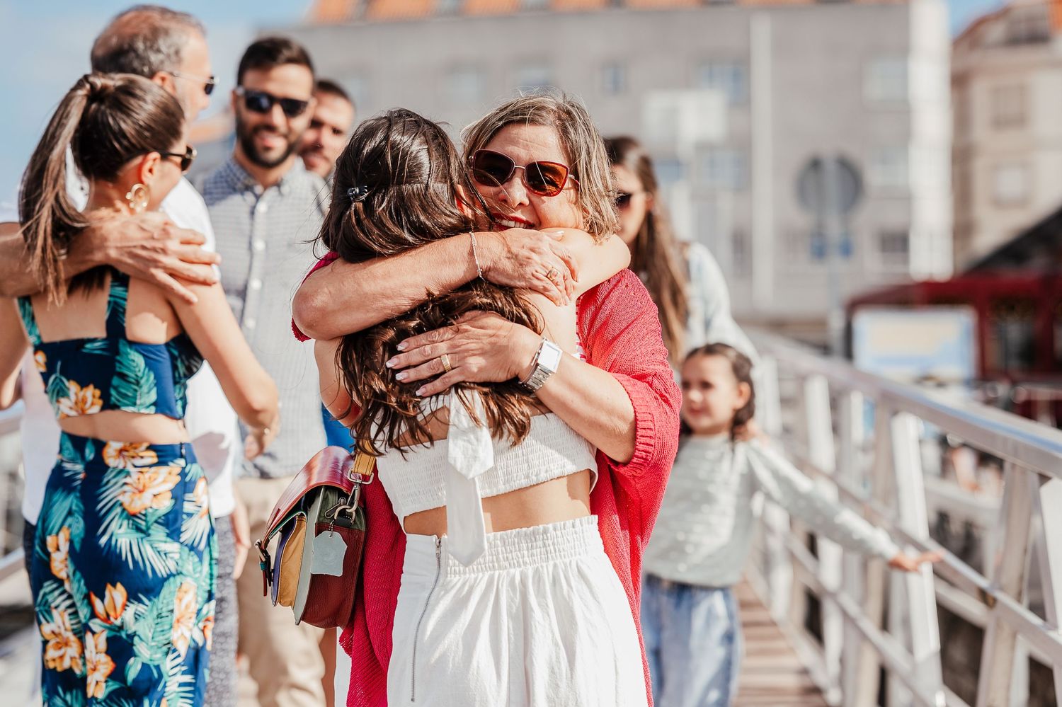 A group of people celebrating and embracing at an outdoor event with joyful expressions.