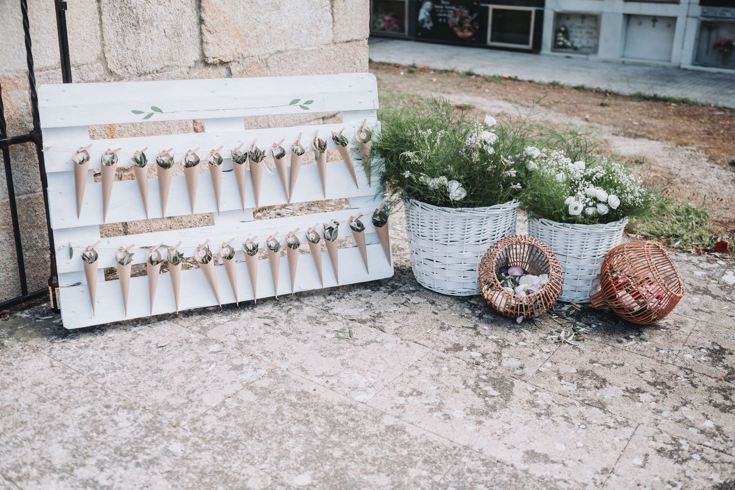 Rustic wedding seating chart display with wooden keys arranged on white board next to potted flowers and decorative items.