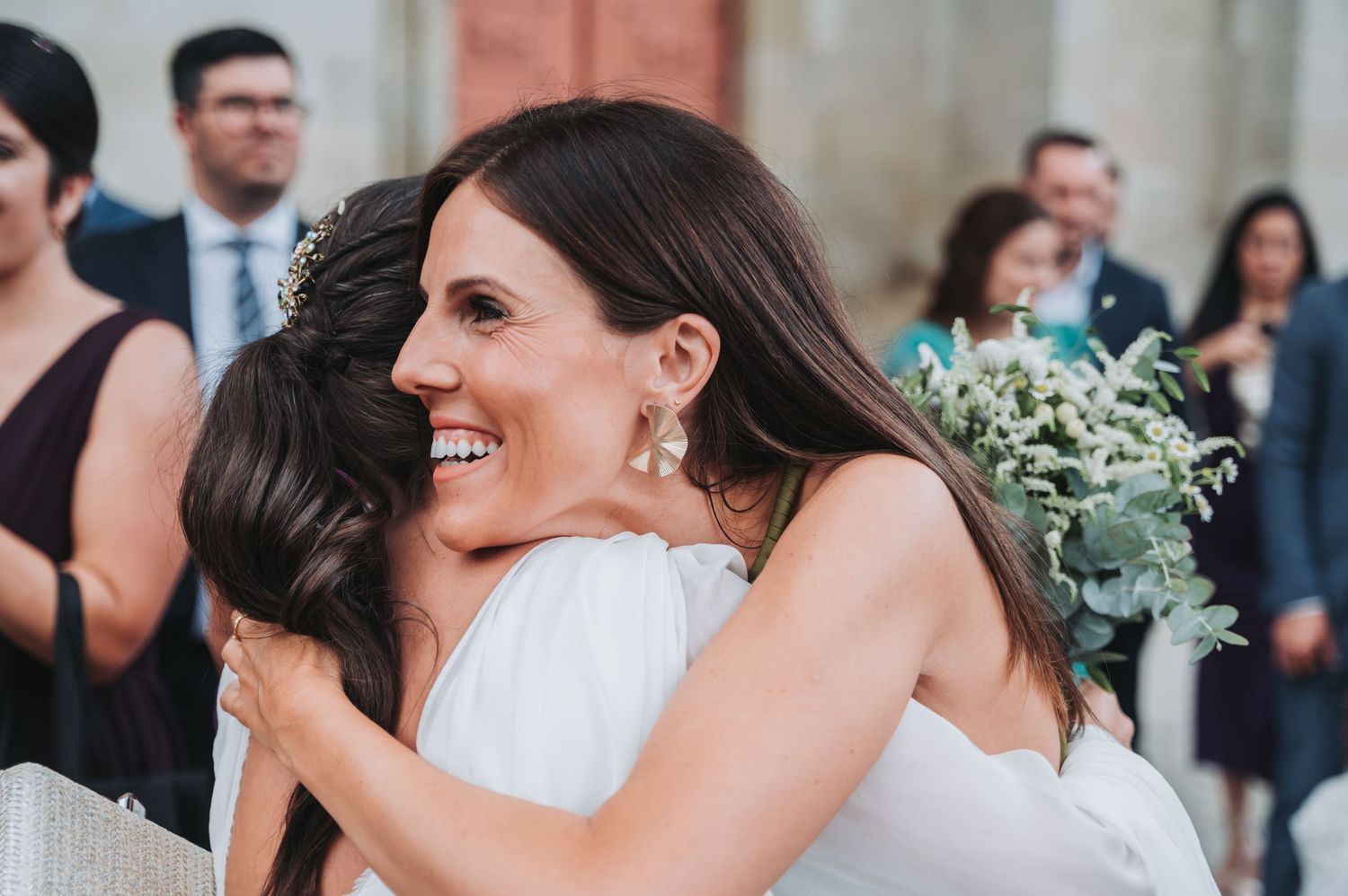 Wedding guests share emotional moments and hugs during the celebration.