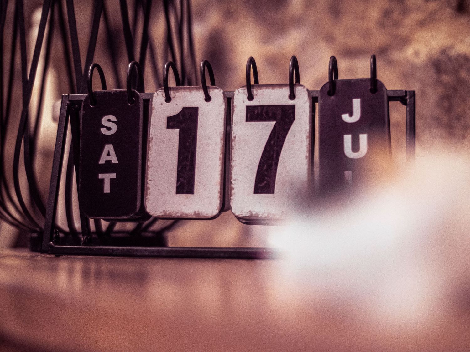Blurred vintage text letters and numbers in sepia tones create an abstract background pattern.