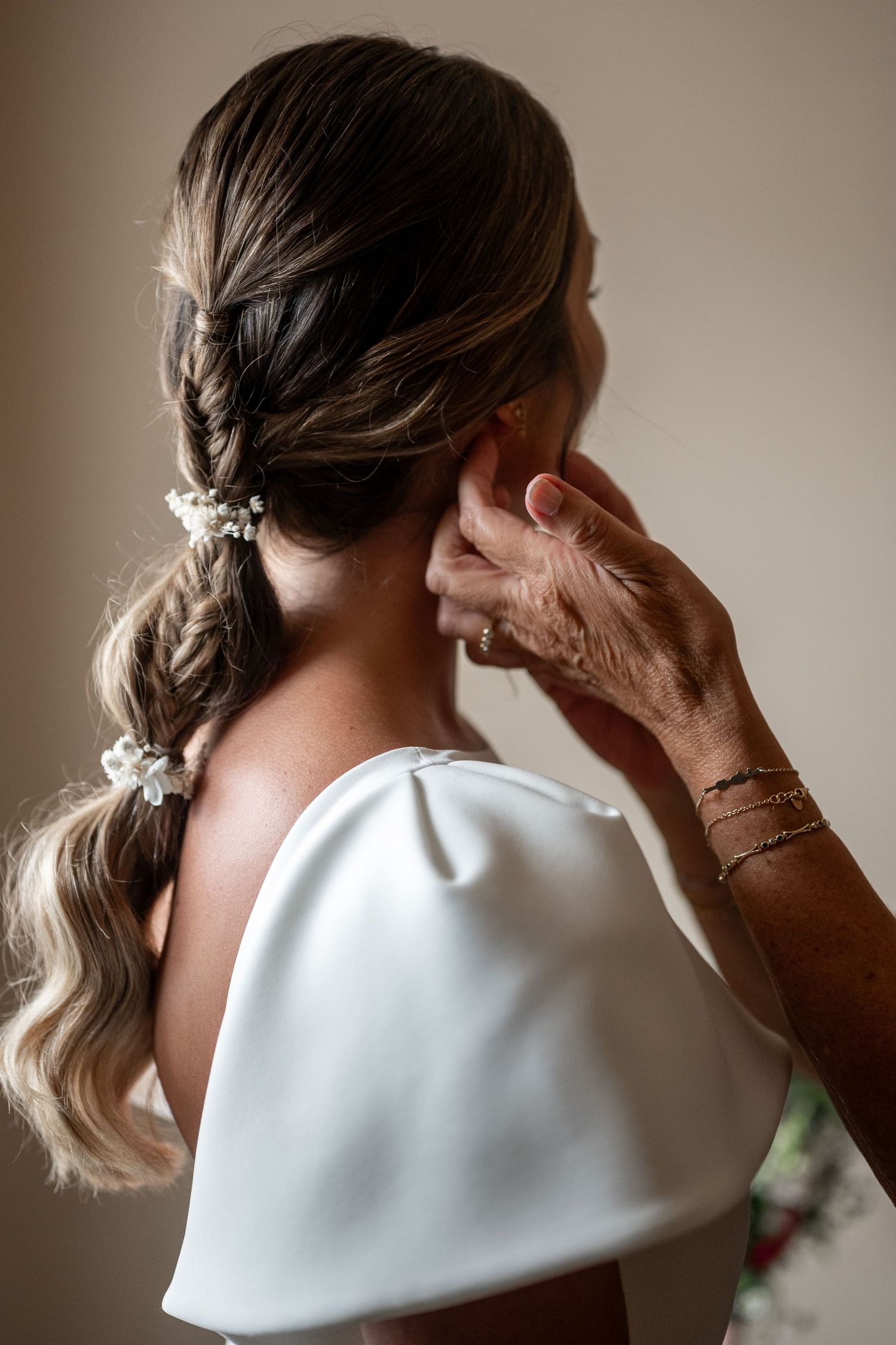 A series of photos showing a white bridal headpiece being styled and secured on a person's hair.