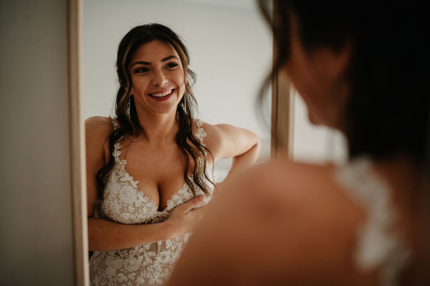 Wedding preparation scene captured in warm, intimate lighting showing dress details.
