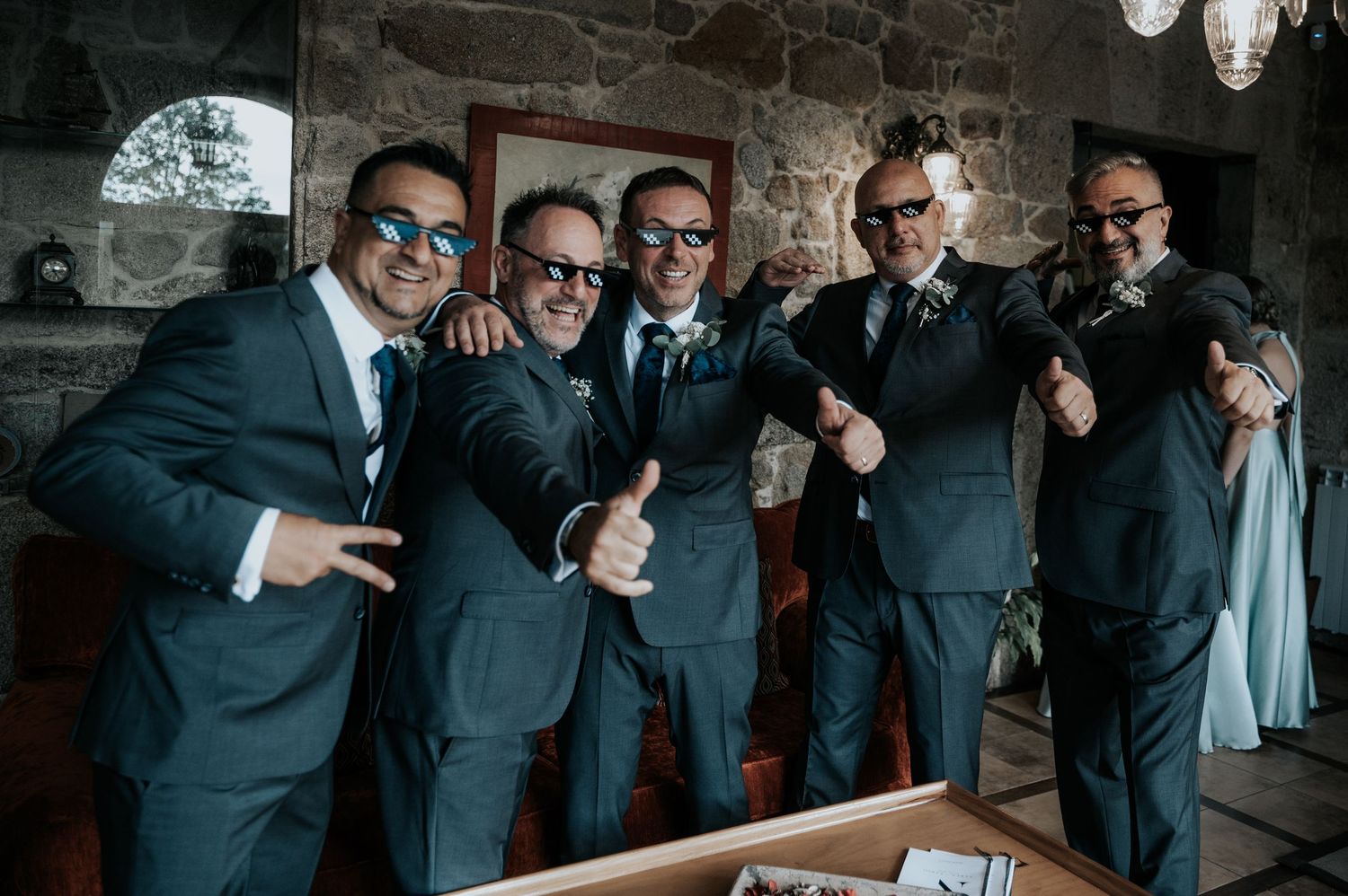 Groomsmen in dark suits pose playfully together in a candid wedding photo sequence.