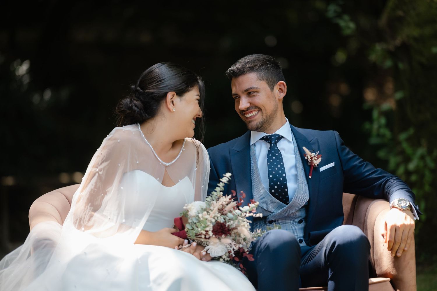 A couple in wedding attire share intimate moments during their outdoor garden photoshoot.