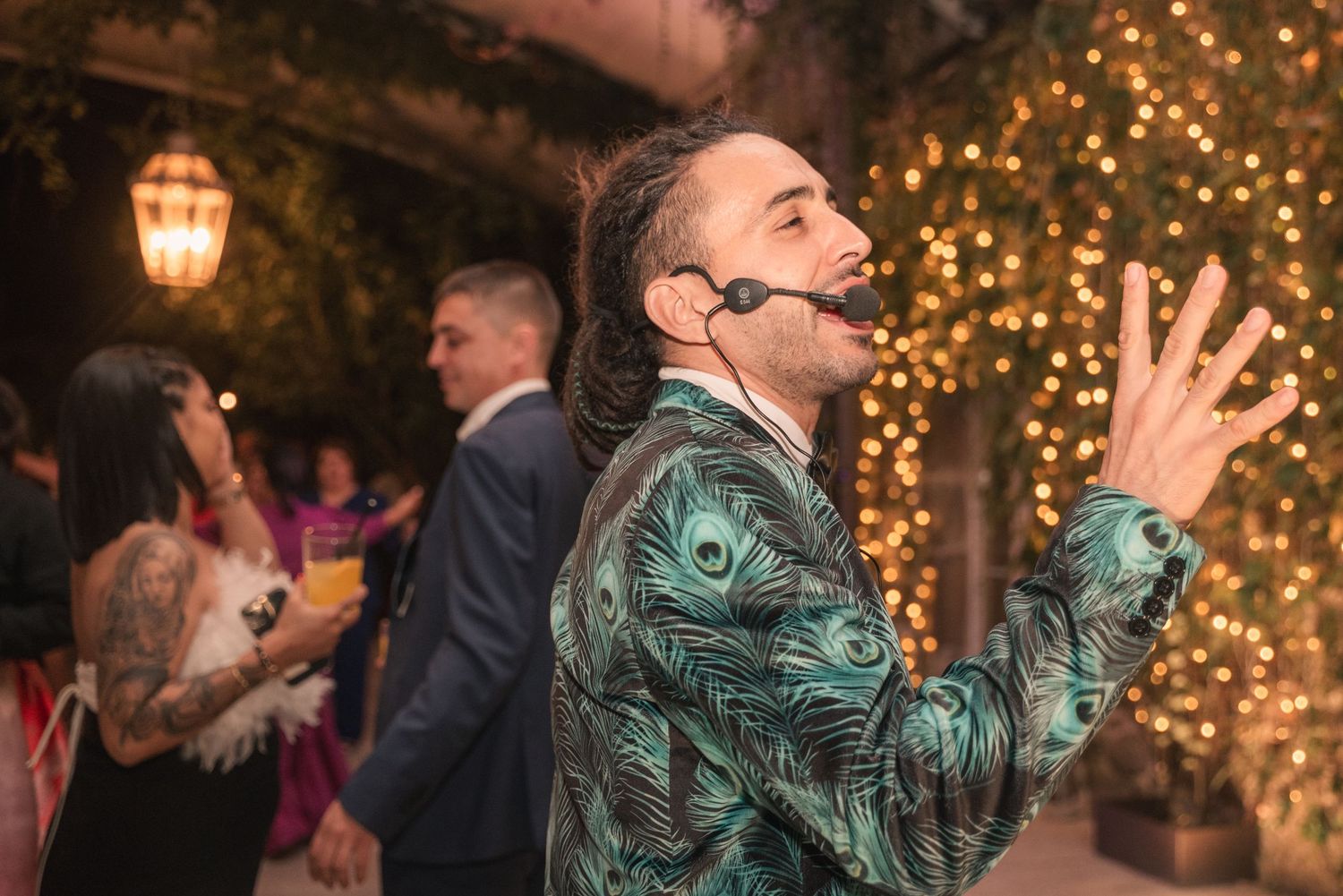 Wedding guests dance and celebrate on a dance floor illuminated by warm string lights and lanterns.