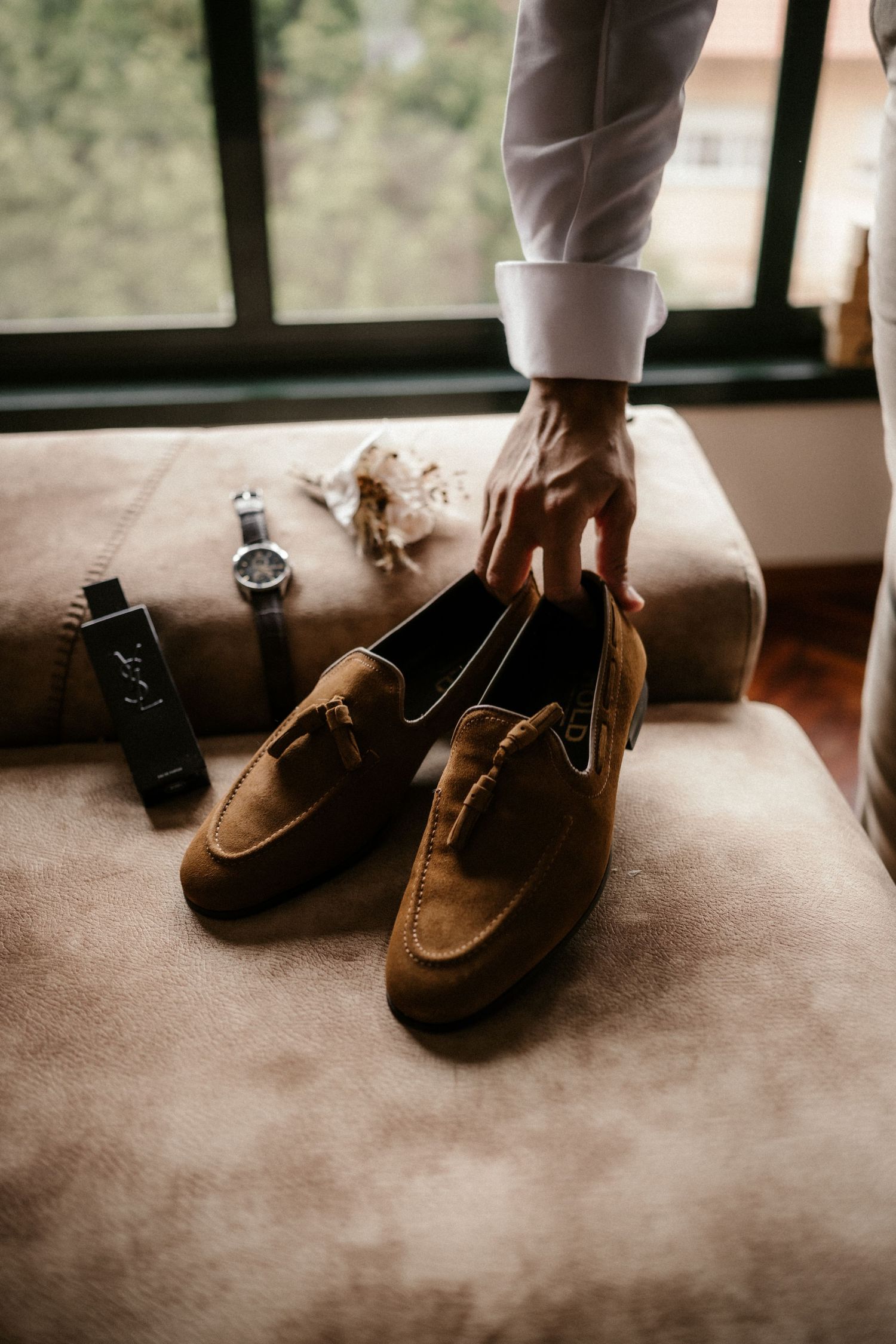 Brown suede boat shoes shown in a sequence of close-up shots on a carpeted floor.