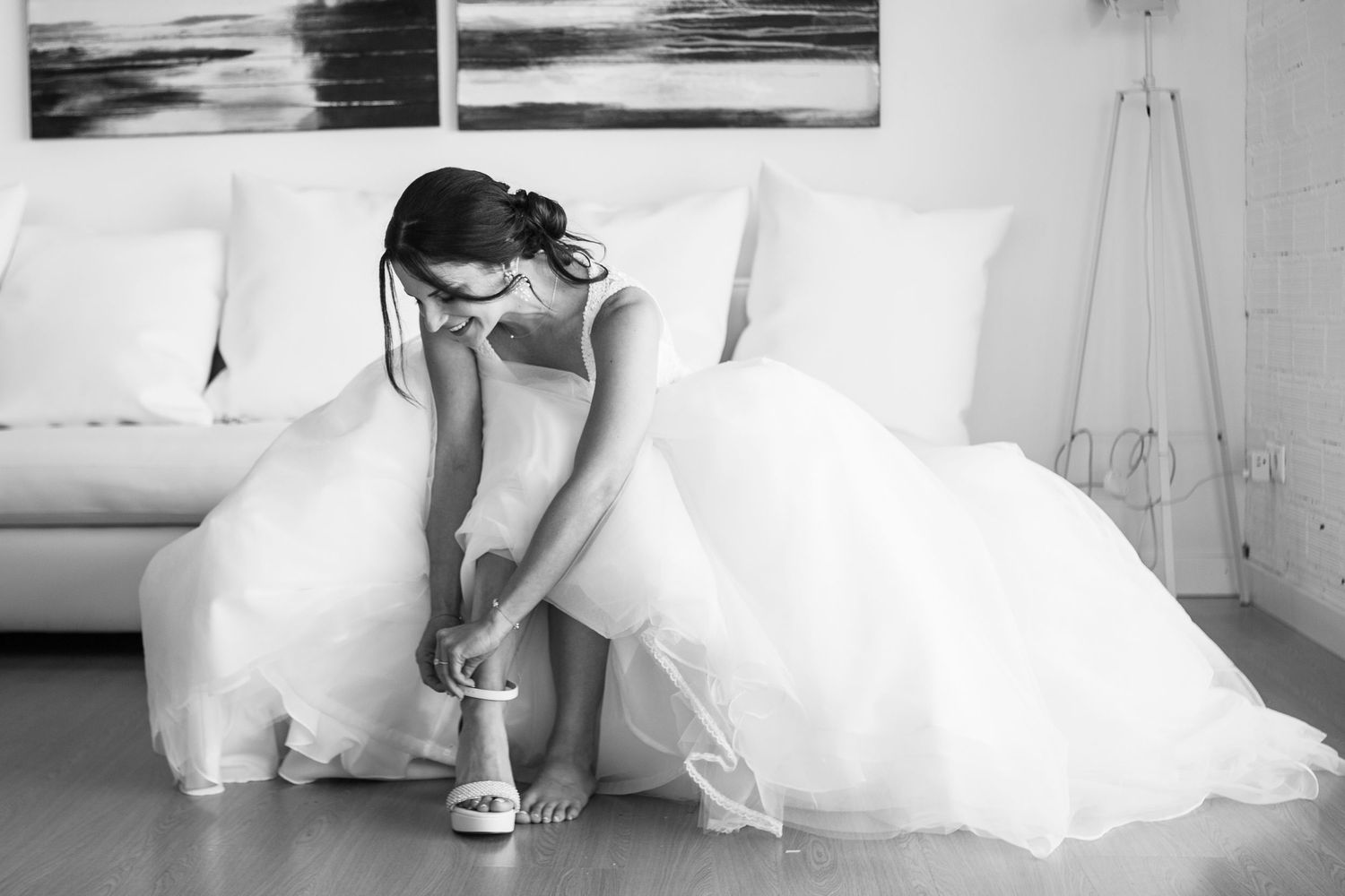 A series of black and white wedding photos showing details of a bride's dress, shoes, and flowing fabric in motion.