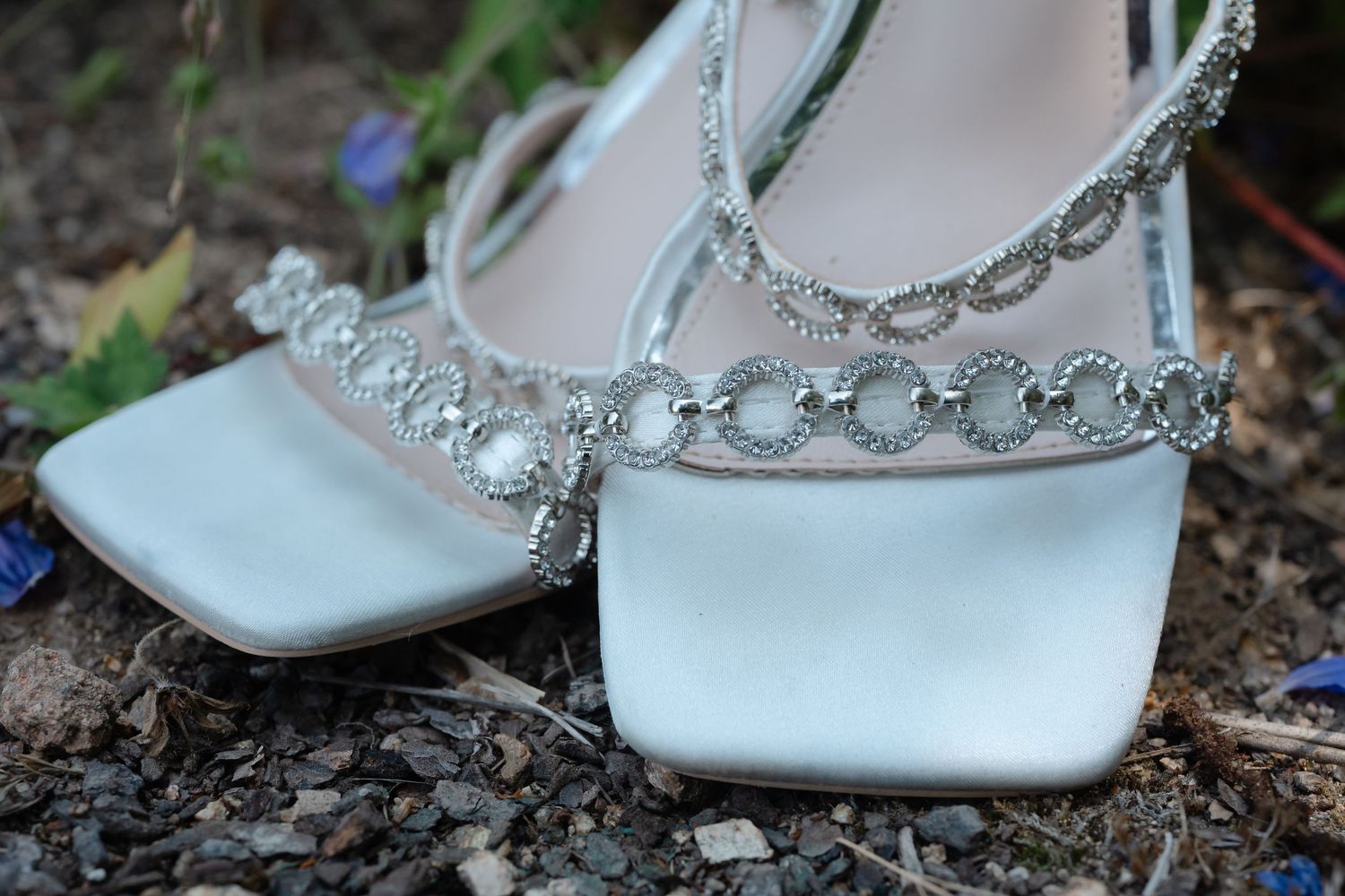 White bridal shoes adorned with delicate crystal embellishments and straps.