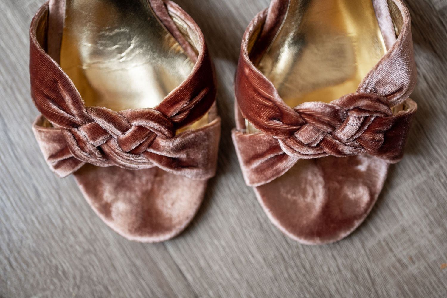 Row of well-worn pink ballet slippers showing progression of use and wear over time.