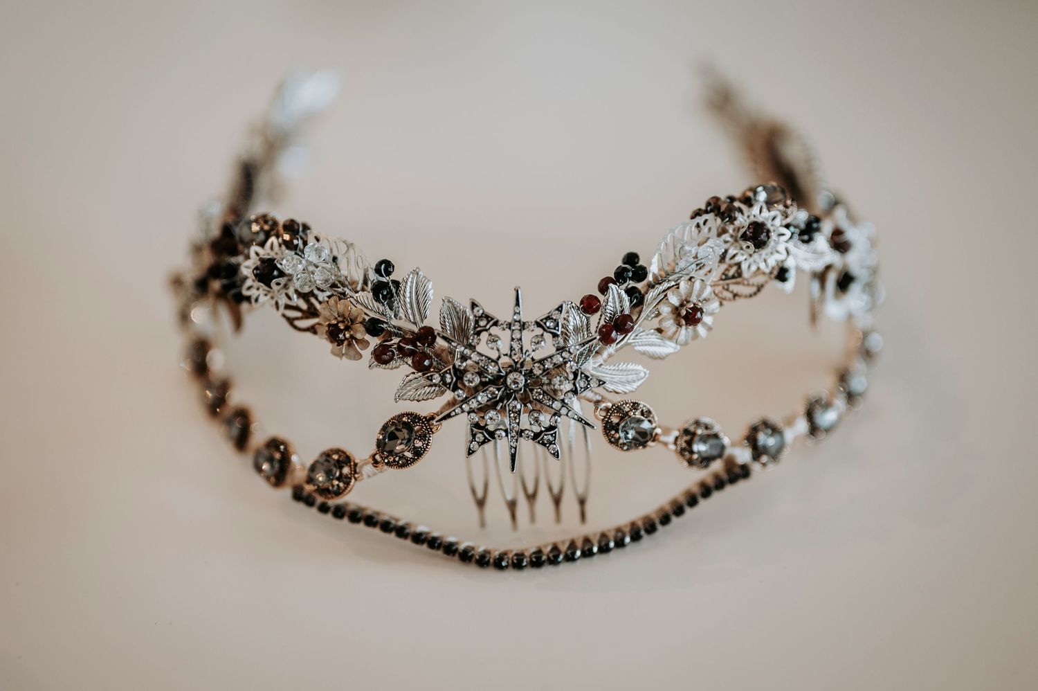 Delicate vintage-style bridal headpiece with crystal embellishments and intricate floral metalwork details in silver tones.