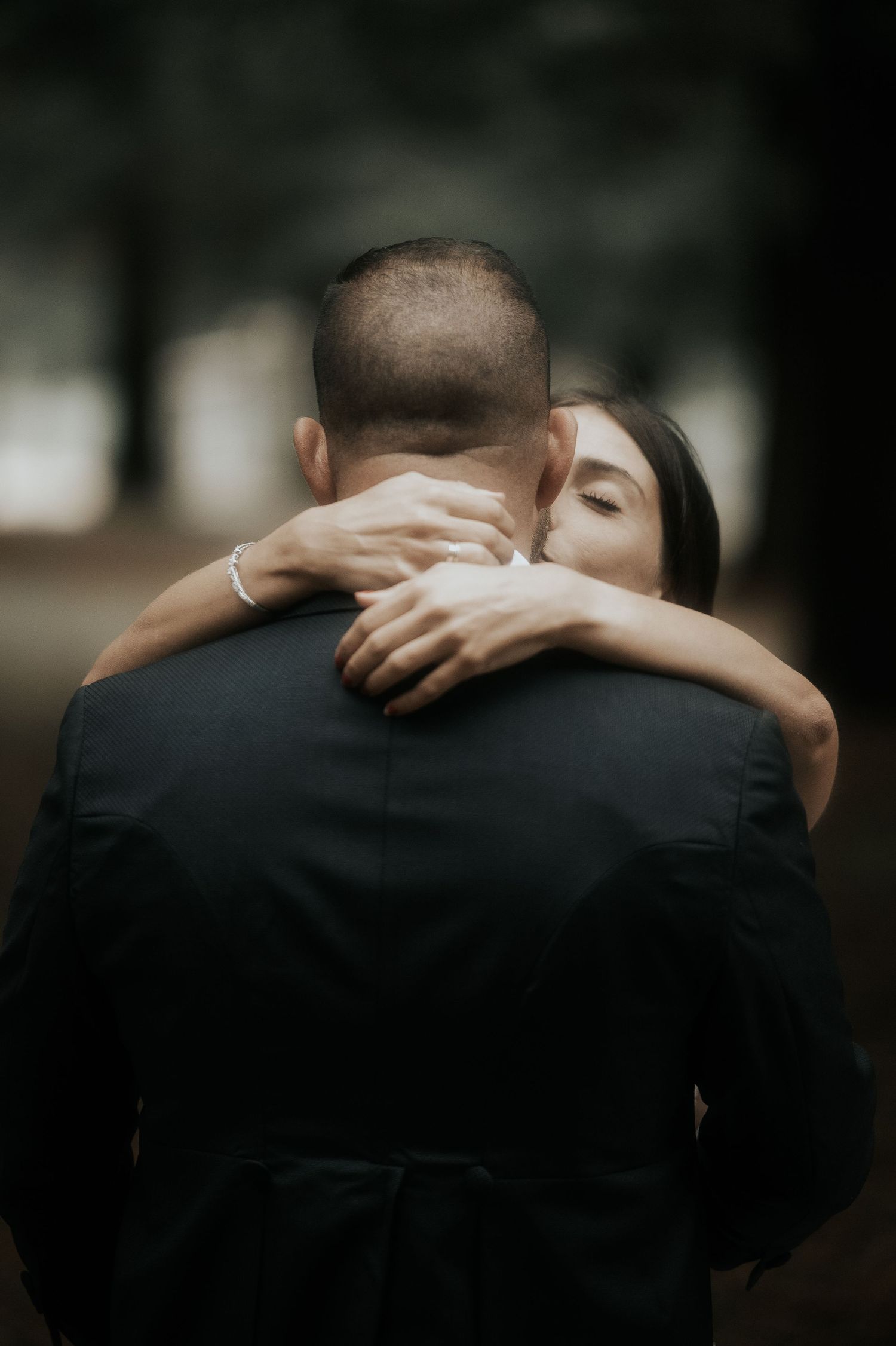 Two people share an intimate embrace against a dark background in a series of cropped emotional photographs.