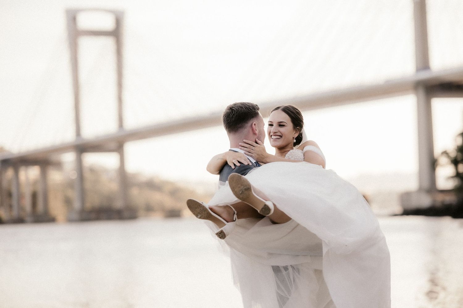 A bride in a flowing white dress twirls gracefully across a sunlit dance floor during a wedding celebration.