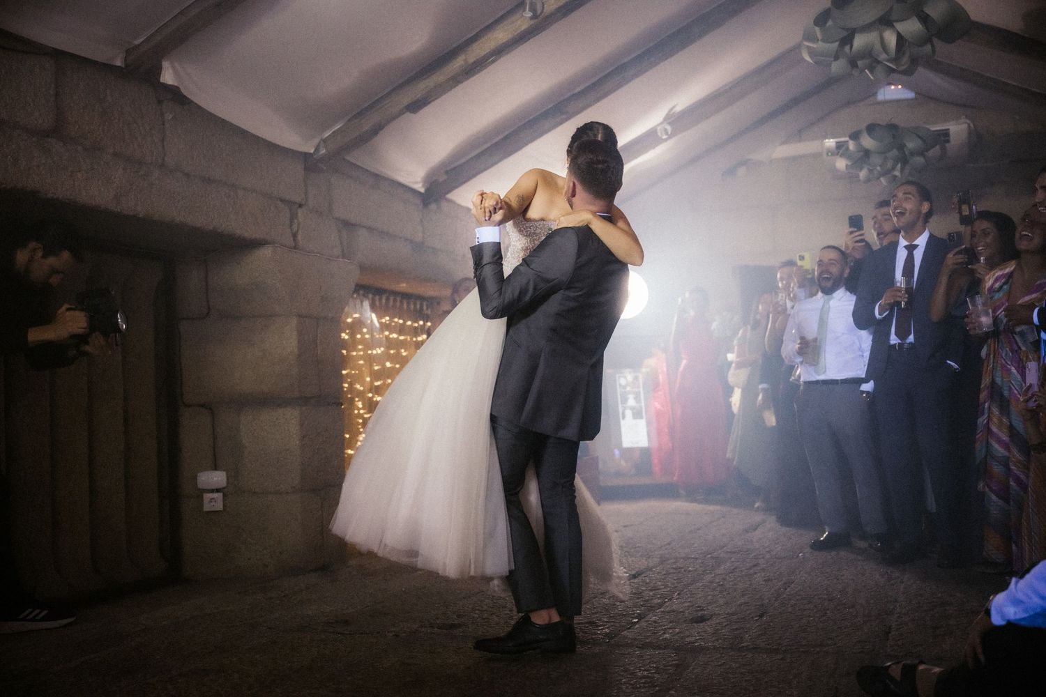 Silhouetted couple dancing in a romantic first dance at their wedding reception with dramatic lighting and fog effects.