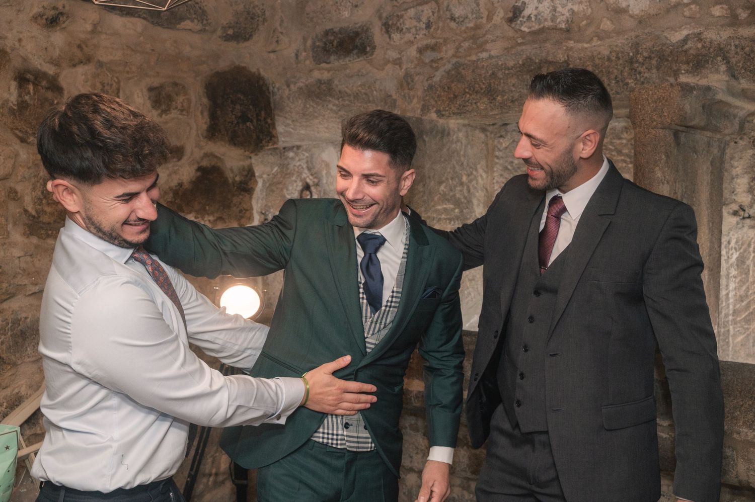 People in formal wear gathered together sharing candid reactions and embraces.