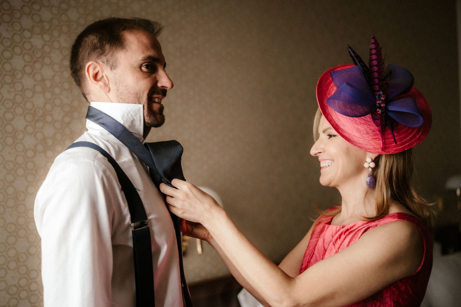 A romantic couple in formal attire dances together in a dimly lit room during an intimate moment.