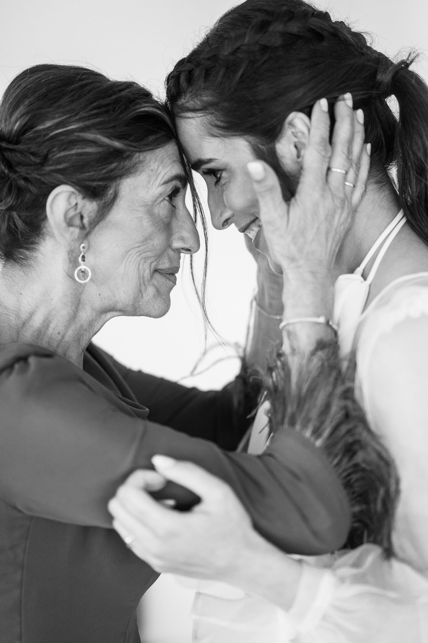 A tender black and white moment shared between two people in formal attire during a special occasion.