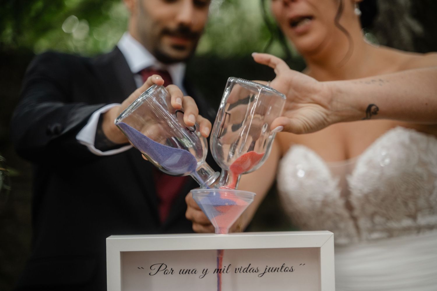 Wedding couple participates in a special drink pouring ceremony outdoors.