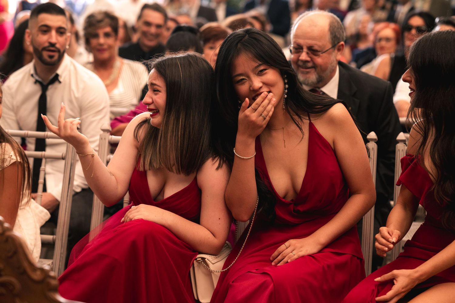 Wedding guests smile and laugh during a joyful reception celebration.