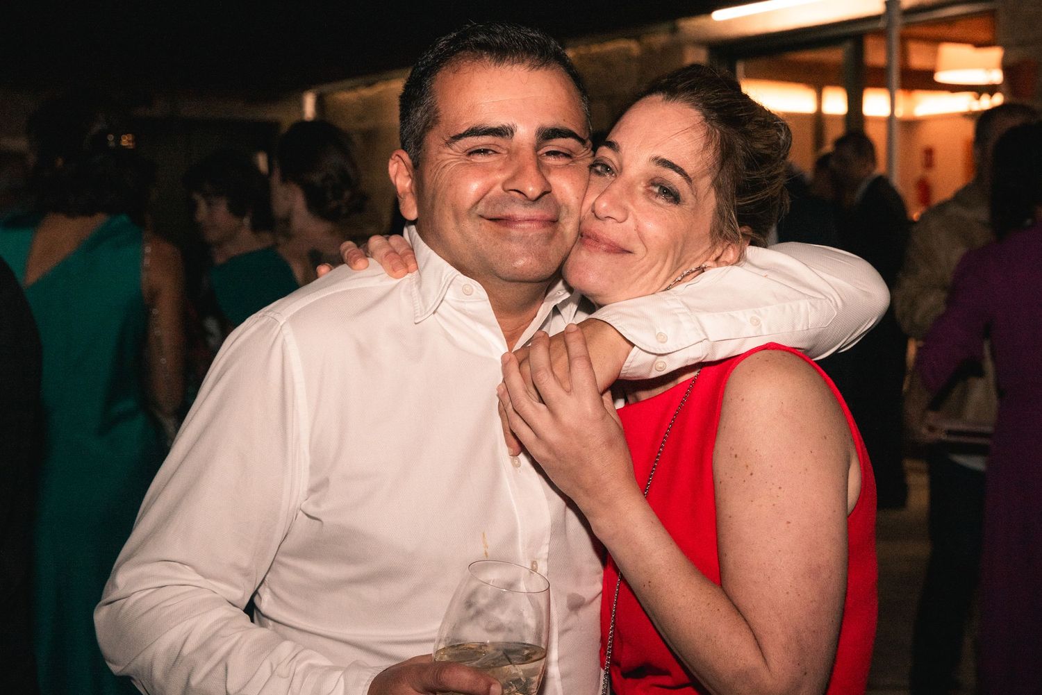 A couple sharing an affectionate moment at an evening celebration event.