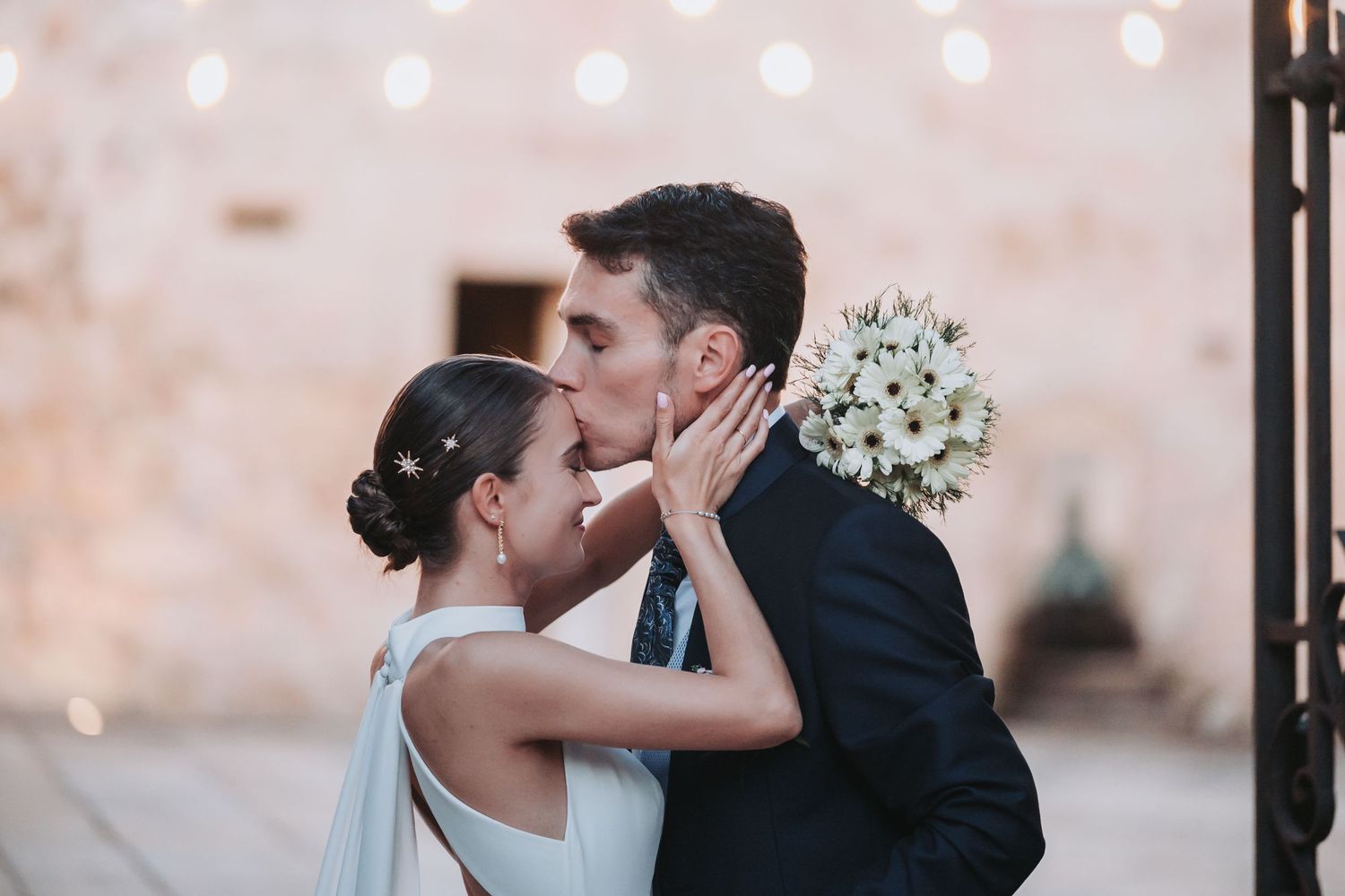 Romantic moment captured against a soft bokeh background at an evening wedding celebration.