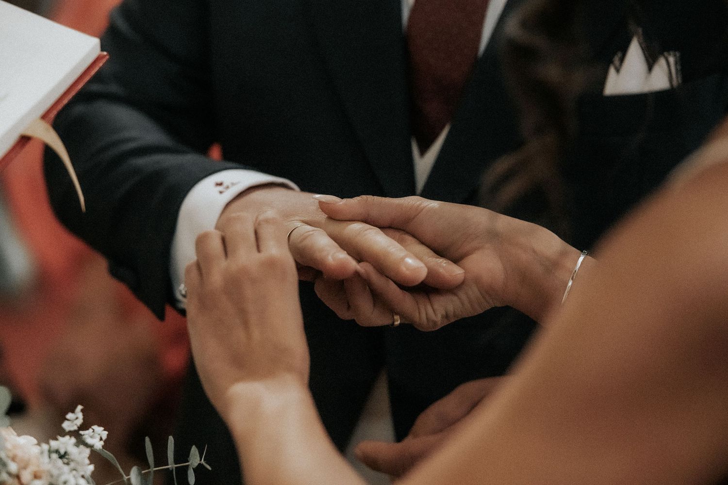 Wedding guests share emotional embraces during a reception celebration.