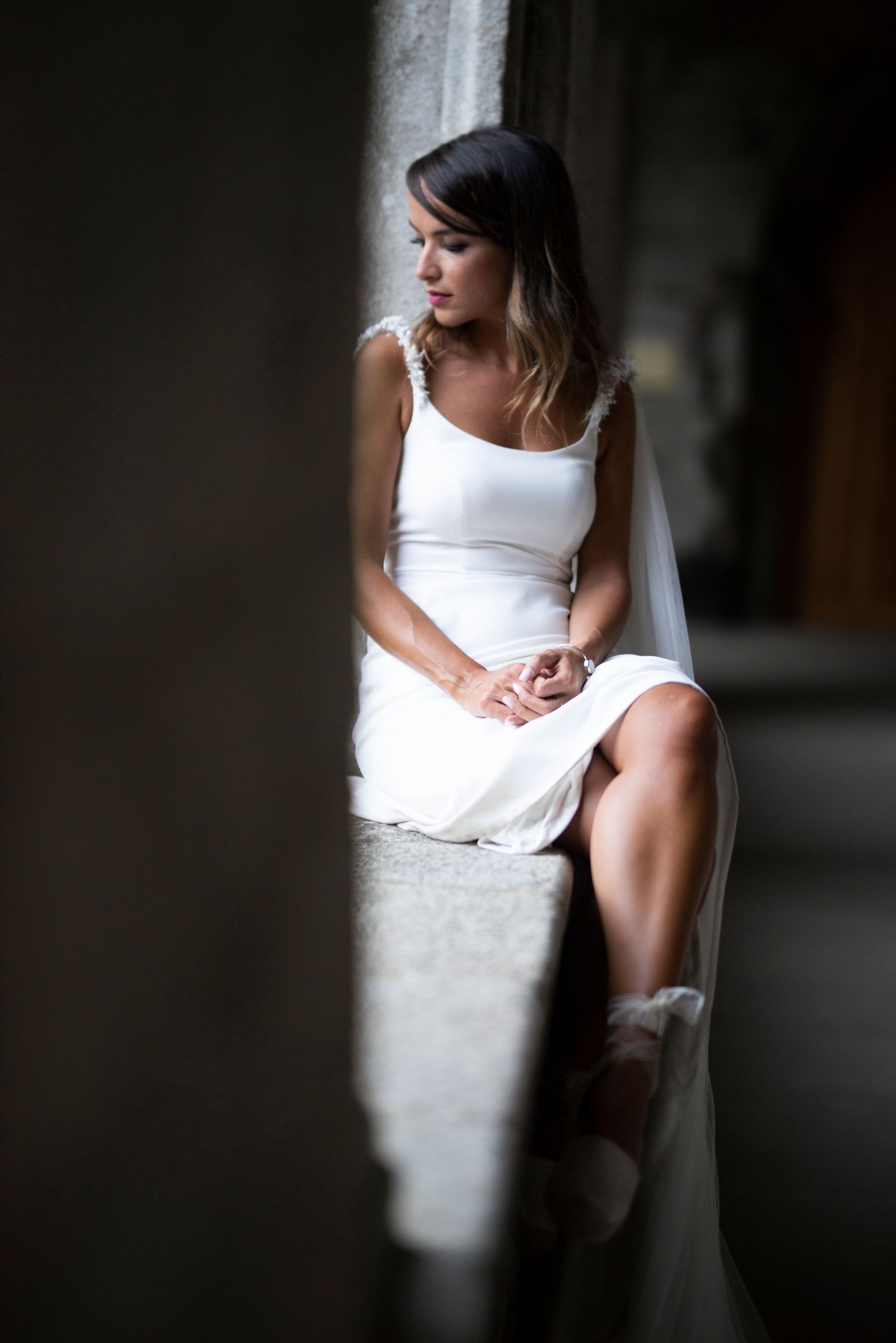 Artistic black and white photo series showing a person in a white dress sitting against a dark background.