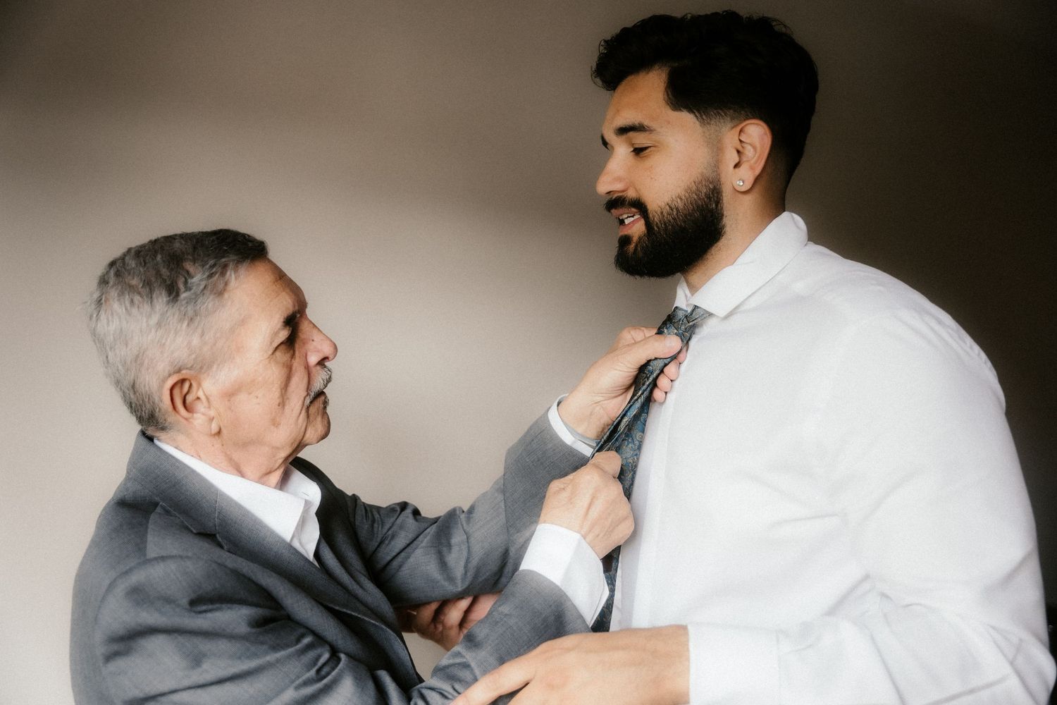 Two people in formal attire prepare for a wedding ceremony in a series of black and white photos.
