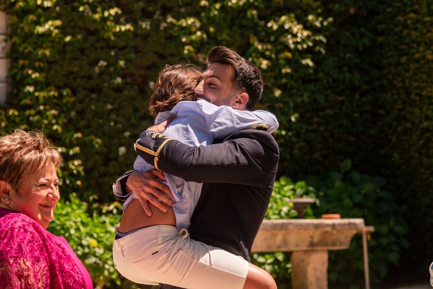 Musicians perform at an elegant outdoor wedding ceremony surrounded by lush greenery.