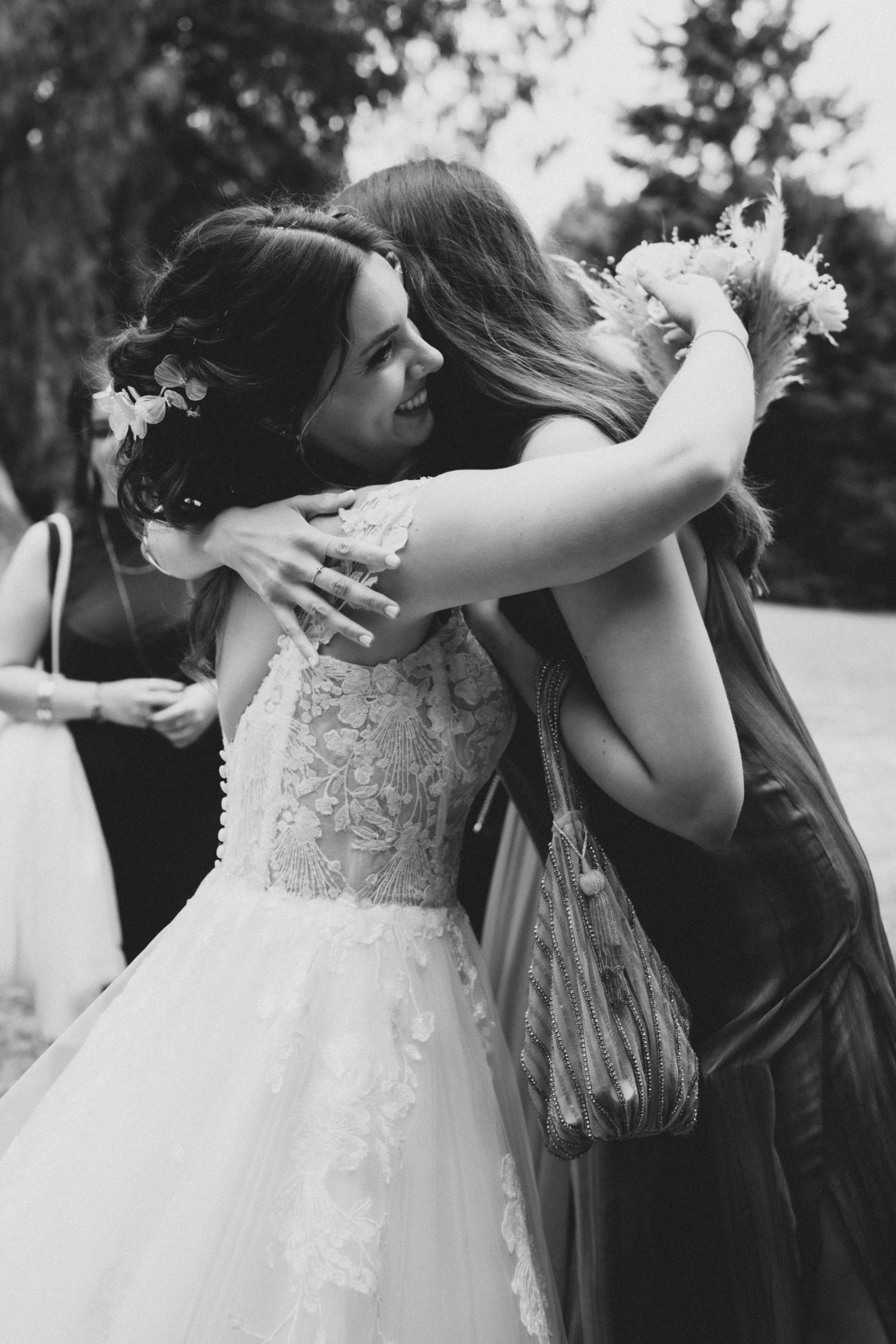A tender moment captured in black and white as the bride embraces someone in an emotional wedding day hug.