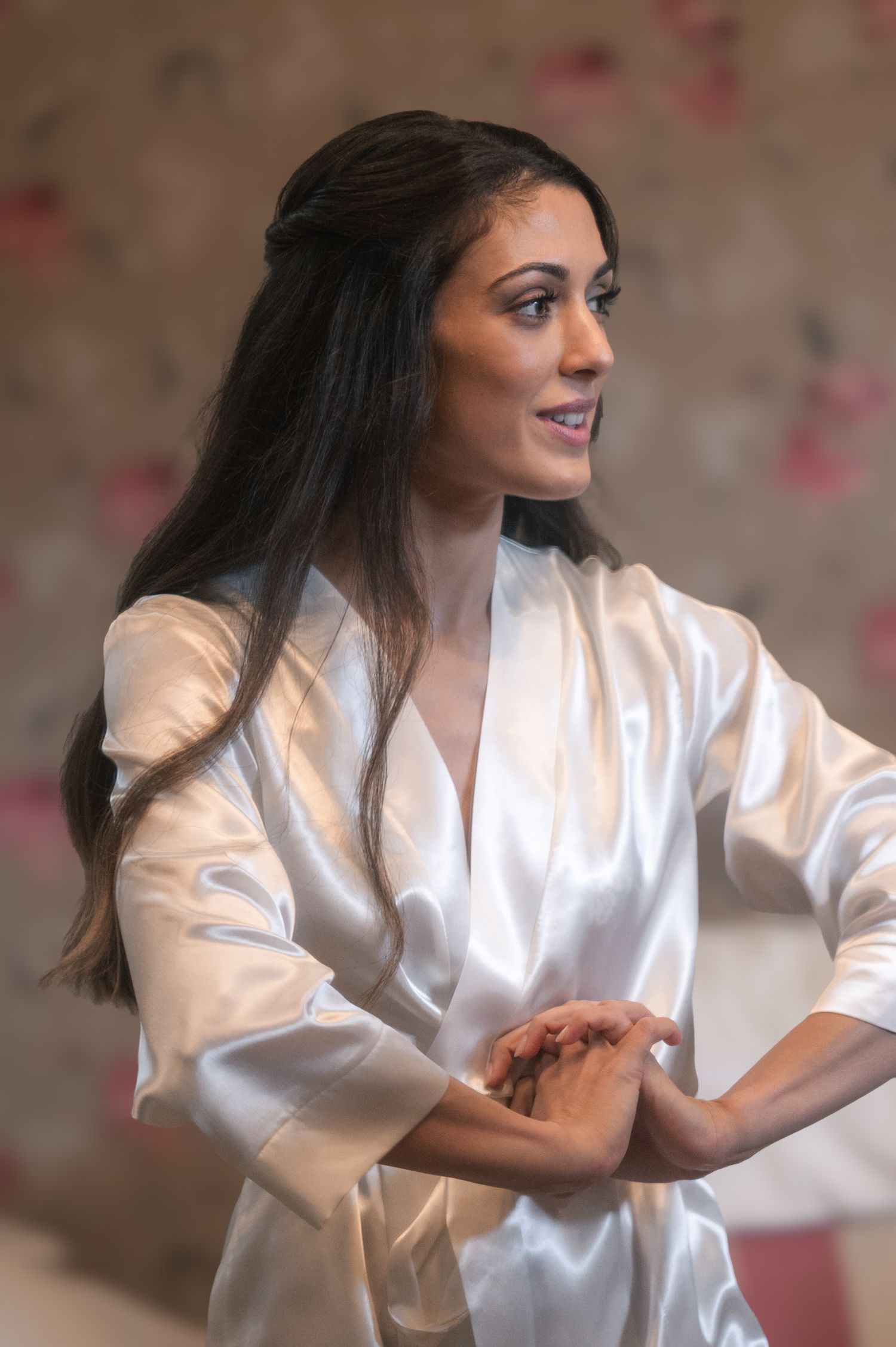 A joyful moment captured during wedding preparations showing a white silk robe.