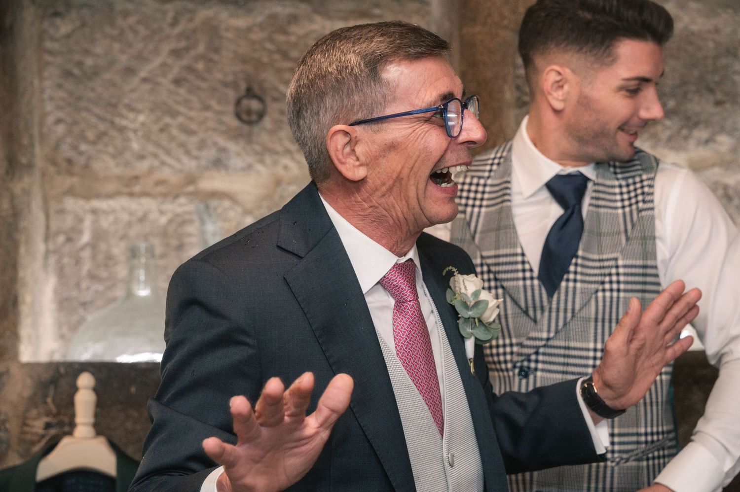 A group of people in formal attire sharing laughter and conversation at a gathering.