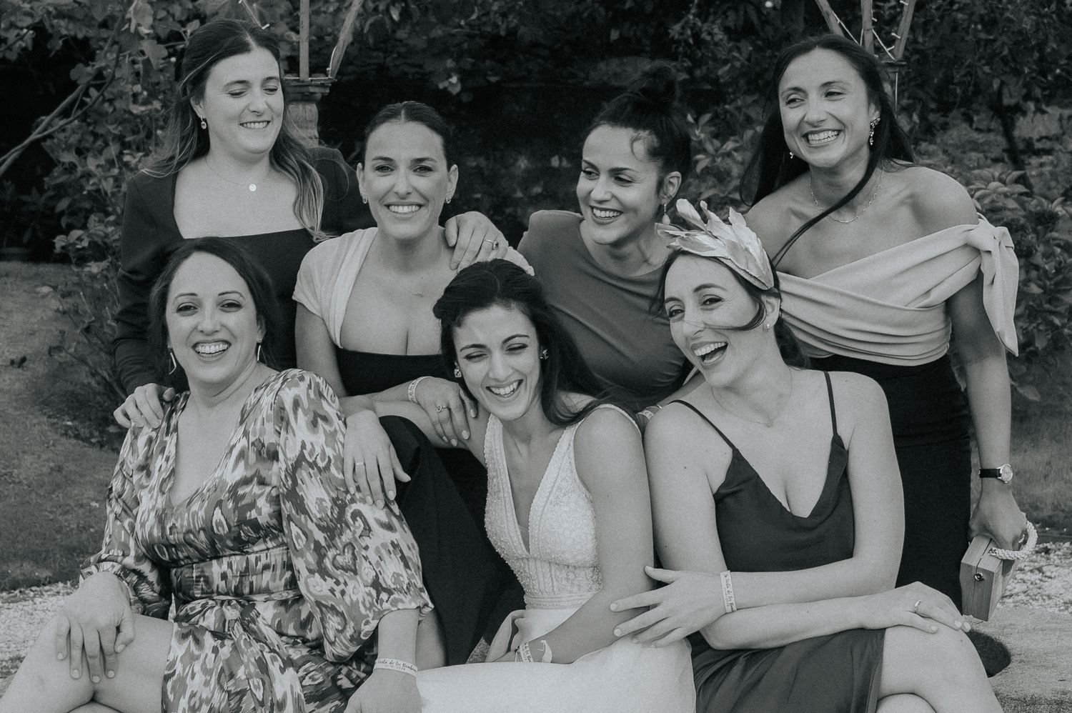 A collection of black and white candid photos showing joyful moments and laughter between friends at an outdoor gathering.