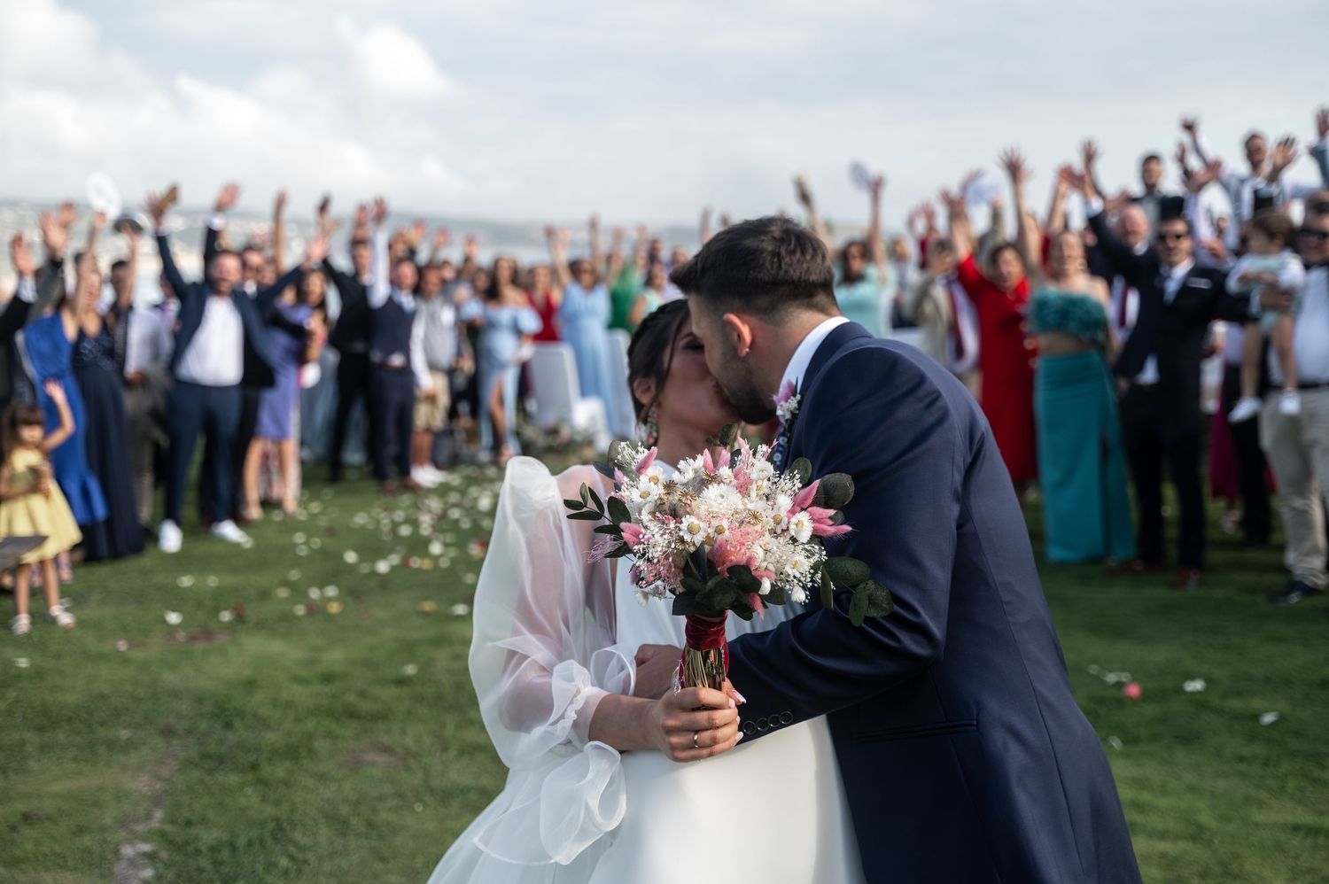 A series of outdoor wedding celebration moments captured at a scenic venue with guests and floral decorations.