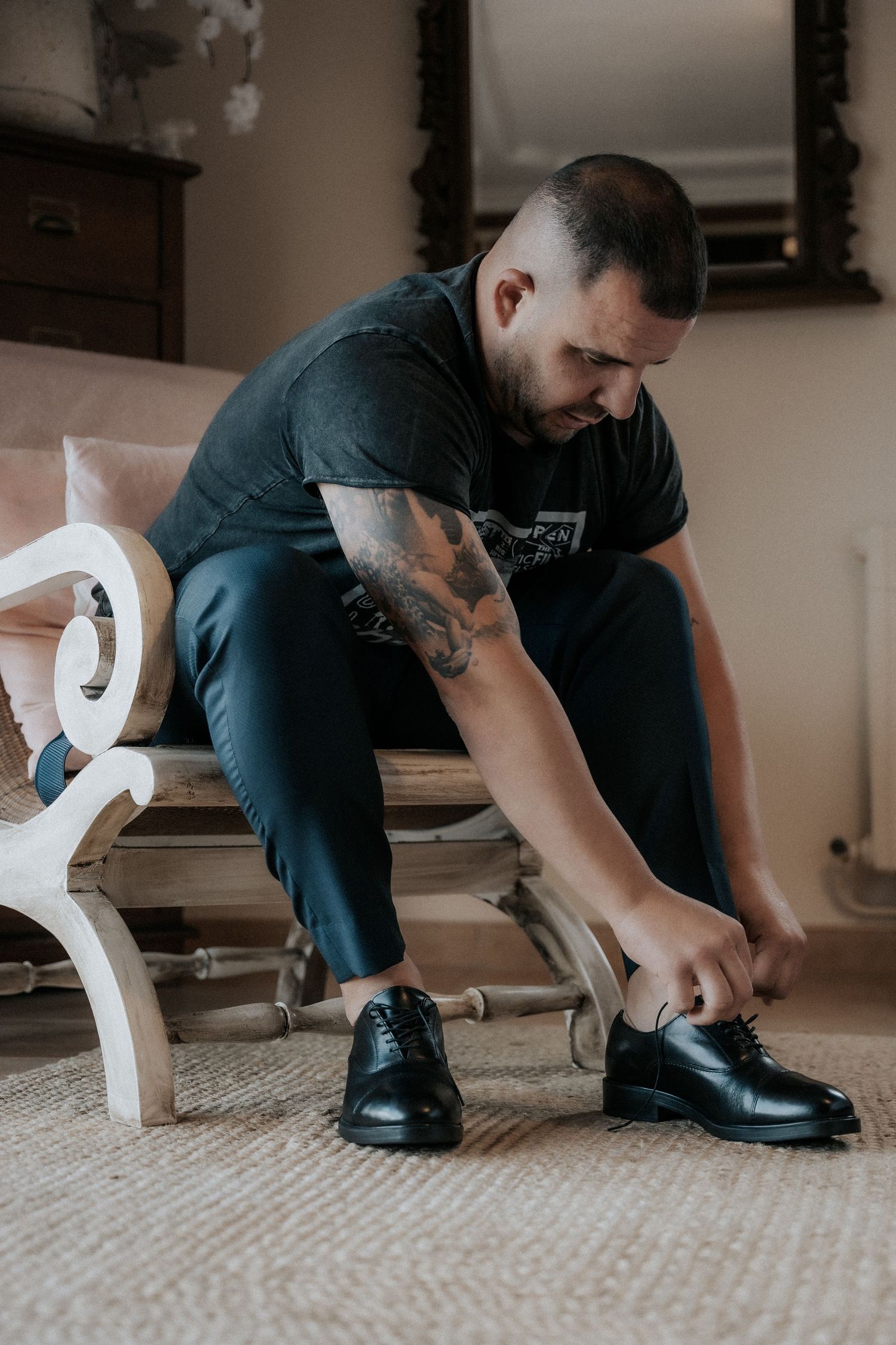 A person in a dark shirt and dress shoes kneels on a carpet while getting ready in a progression of images.