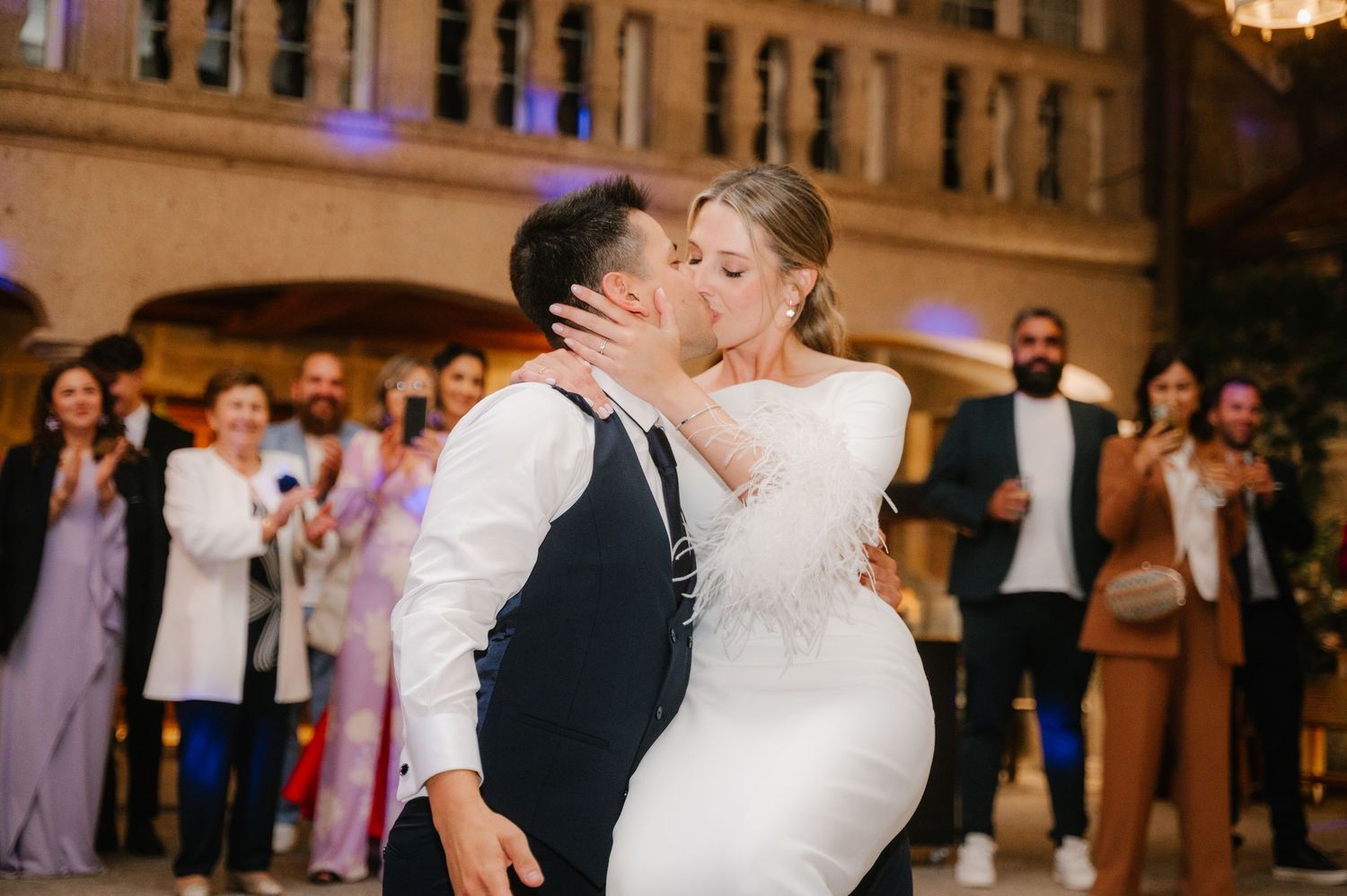 Newlyweds dance together during their first dance at a grand ballroom wedding reception.