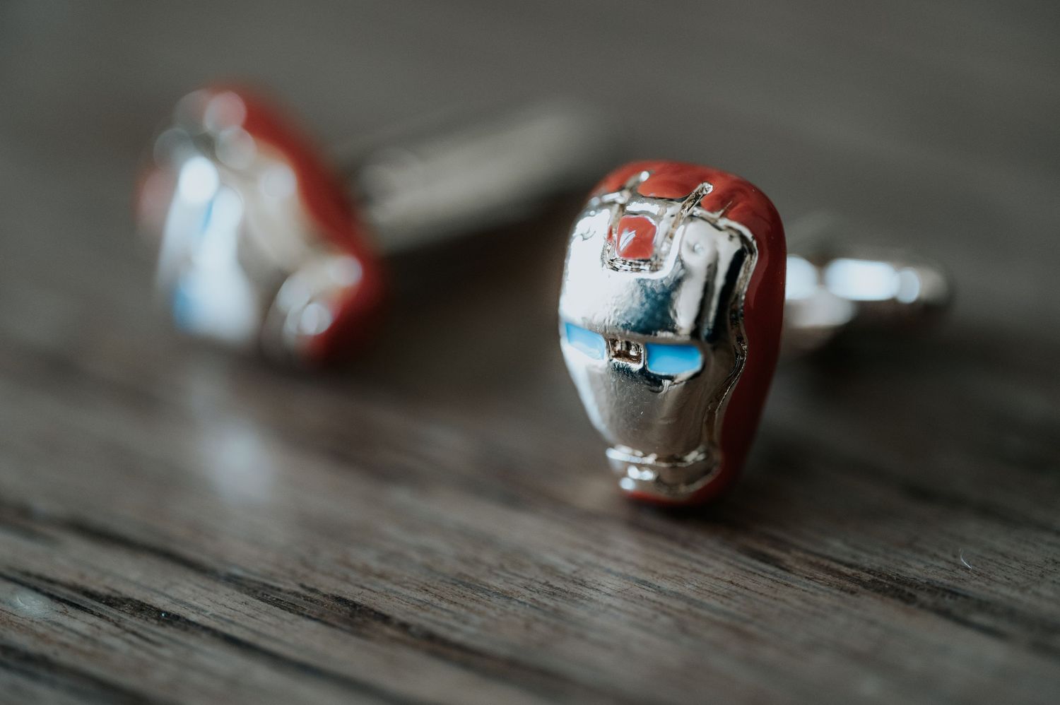 Red and white marbles or decorative spheres scattered on a rustic wooden surface.